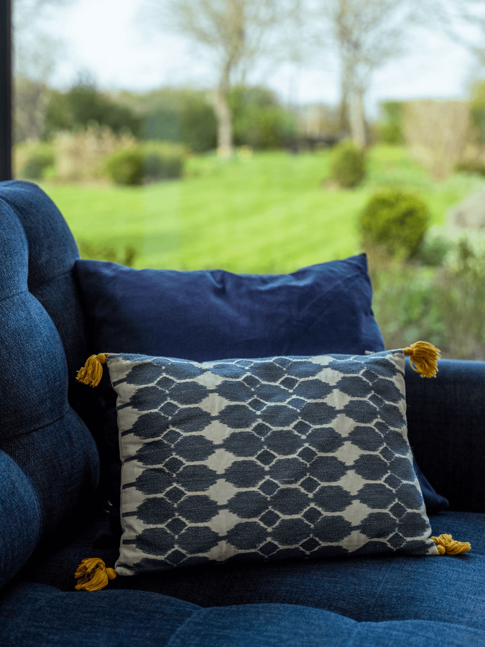 Kent home interiors with patterned cushion on a blue sofa in a light-filled living space