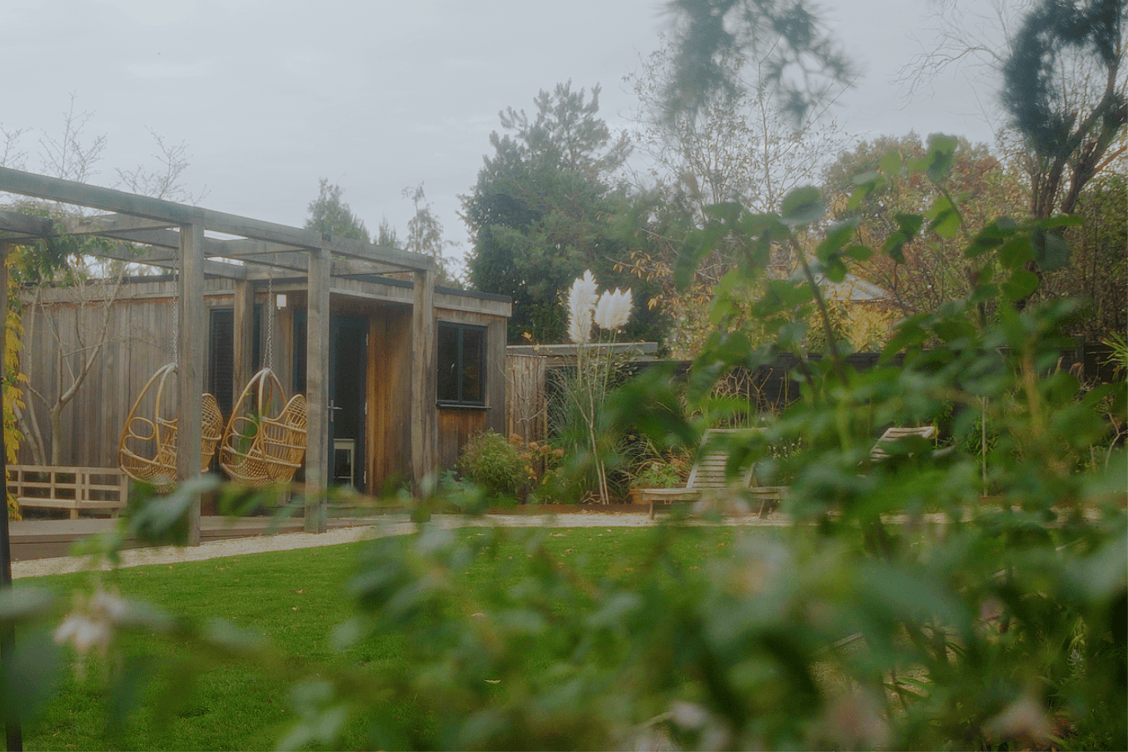 Beckenham garden design with timber garden room, pergola seating and layered planting