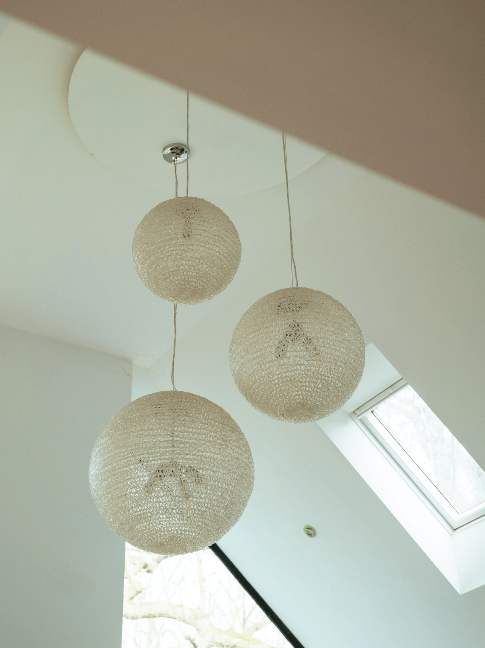 Kent home interiors featuring textured globe pendant lights in a double-height vaulted space