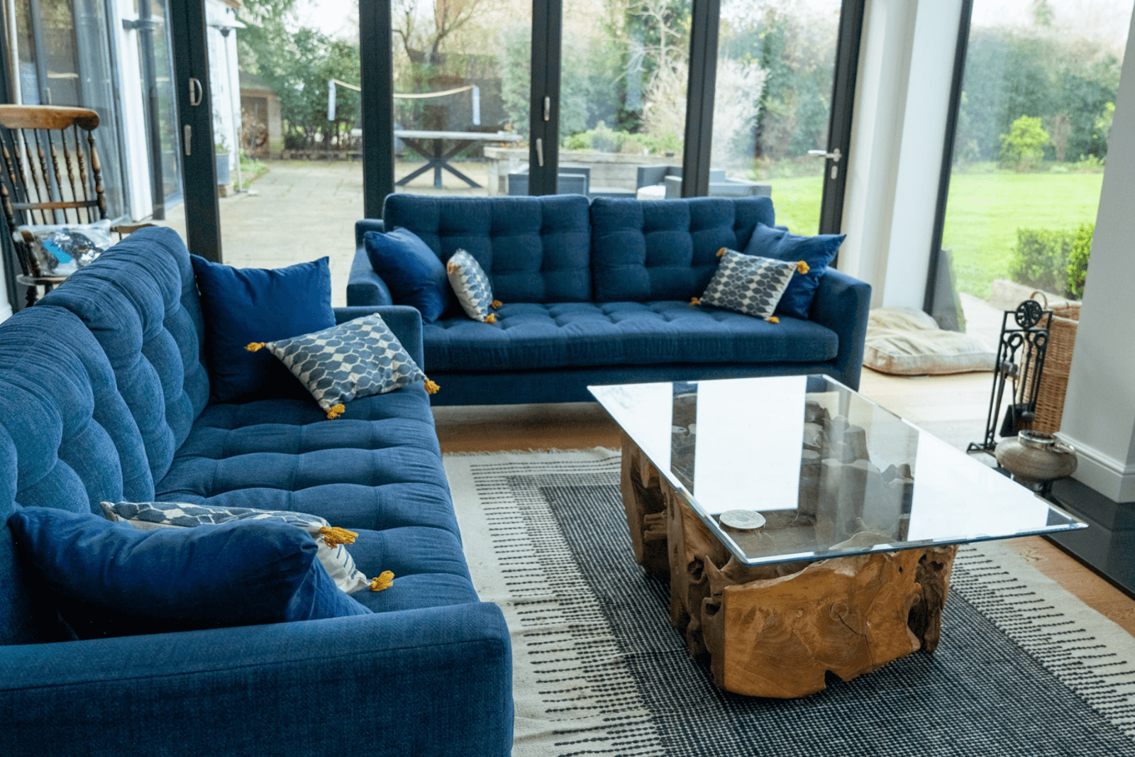 Kent home interiors with blue sofas and a glass top wood coffee table in a light-filled living room