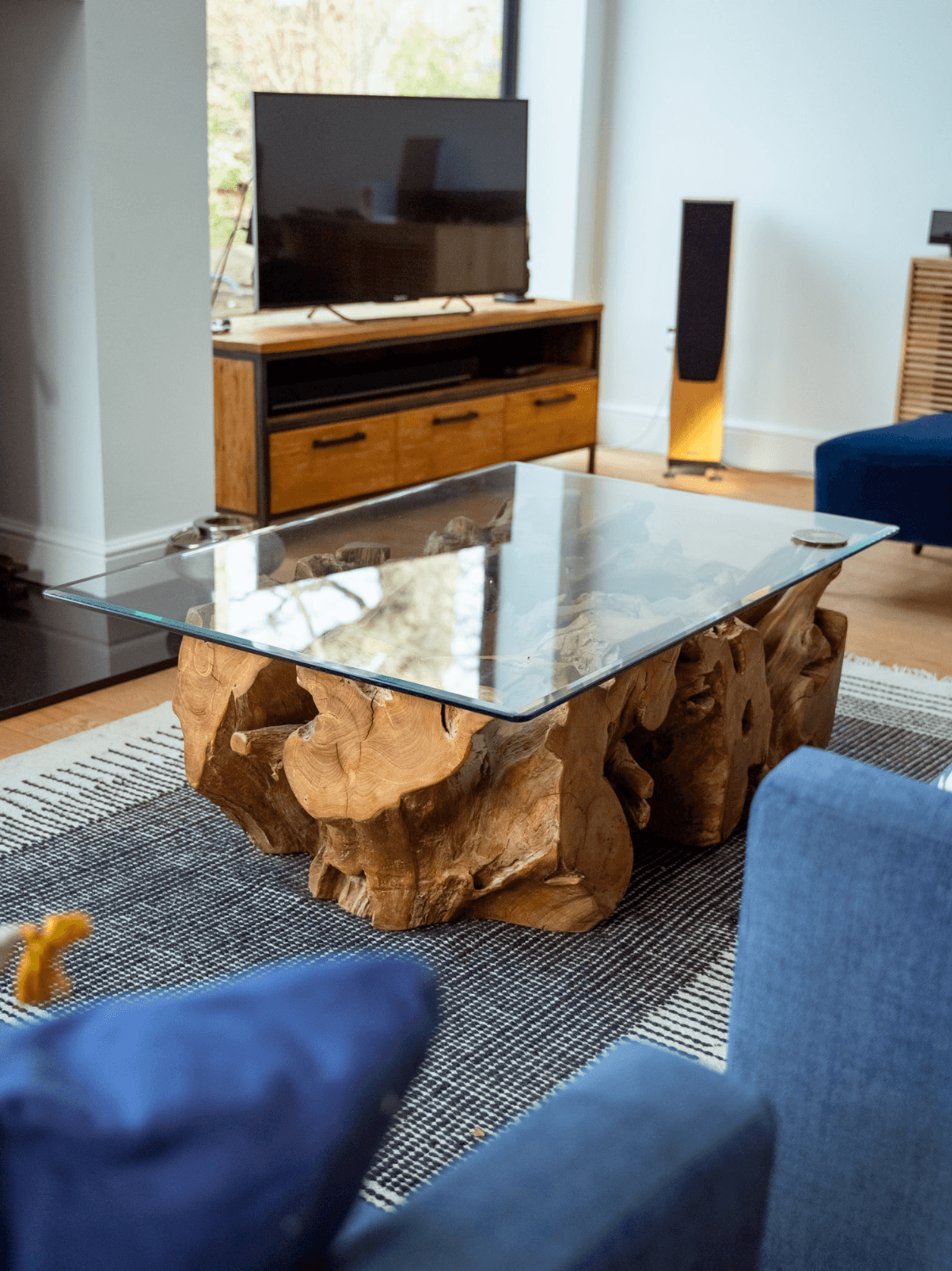 Kent home interiors with a sculptural root wood coffee table and glass top in a modern living space