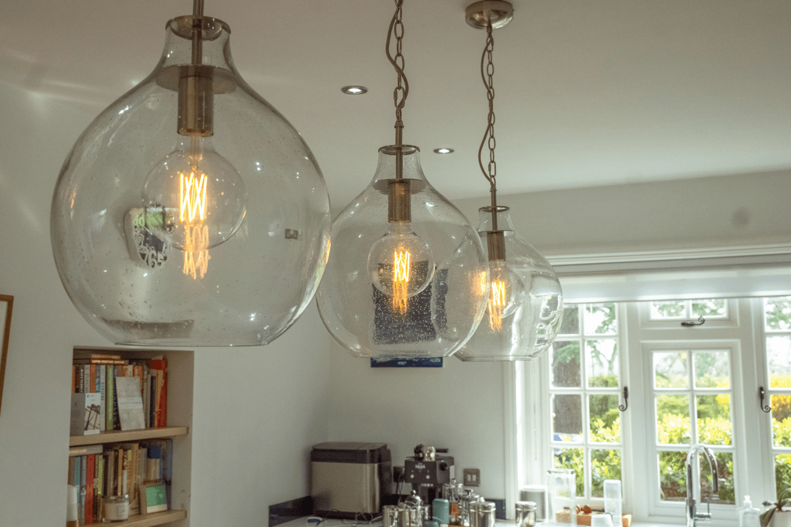 Kent home interiors with hand-blown glass pendant lighting and exposed filament bulbs above a kitchen island