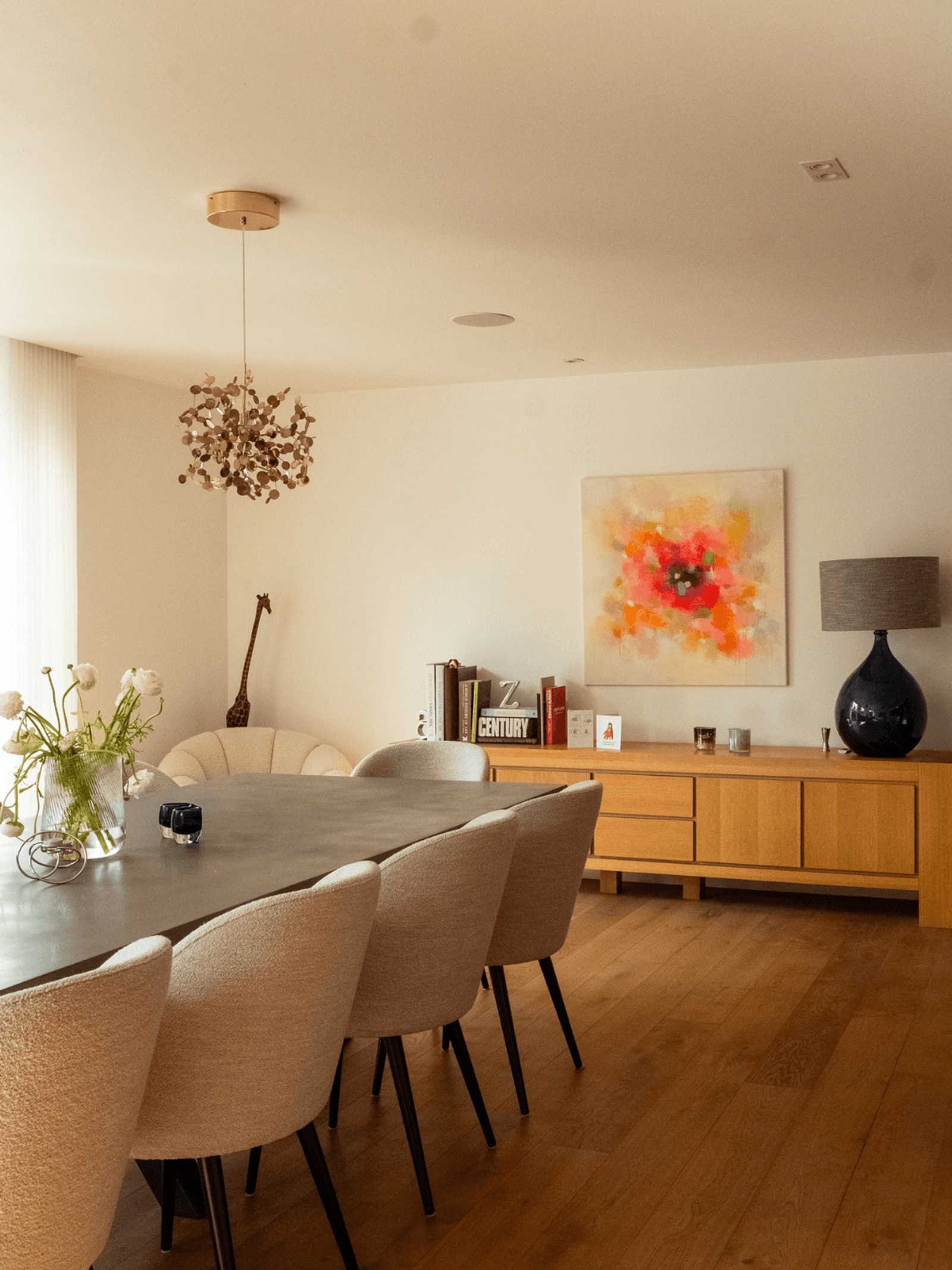 Sevenoaks interior design dining room with wooden sideboard, abstract artwork and contemporary lighting