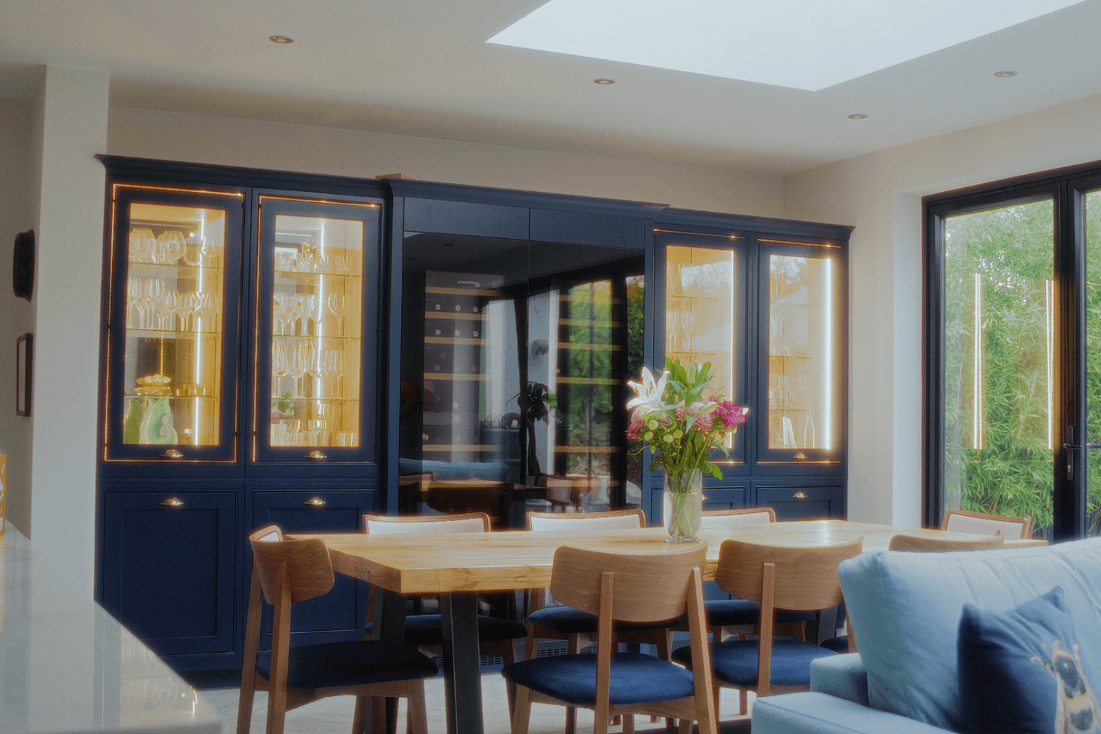Beckenham home interiors dining room with timber table, blue glass cabinet and built-in wine storage