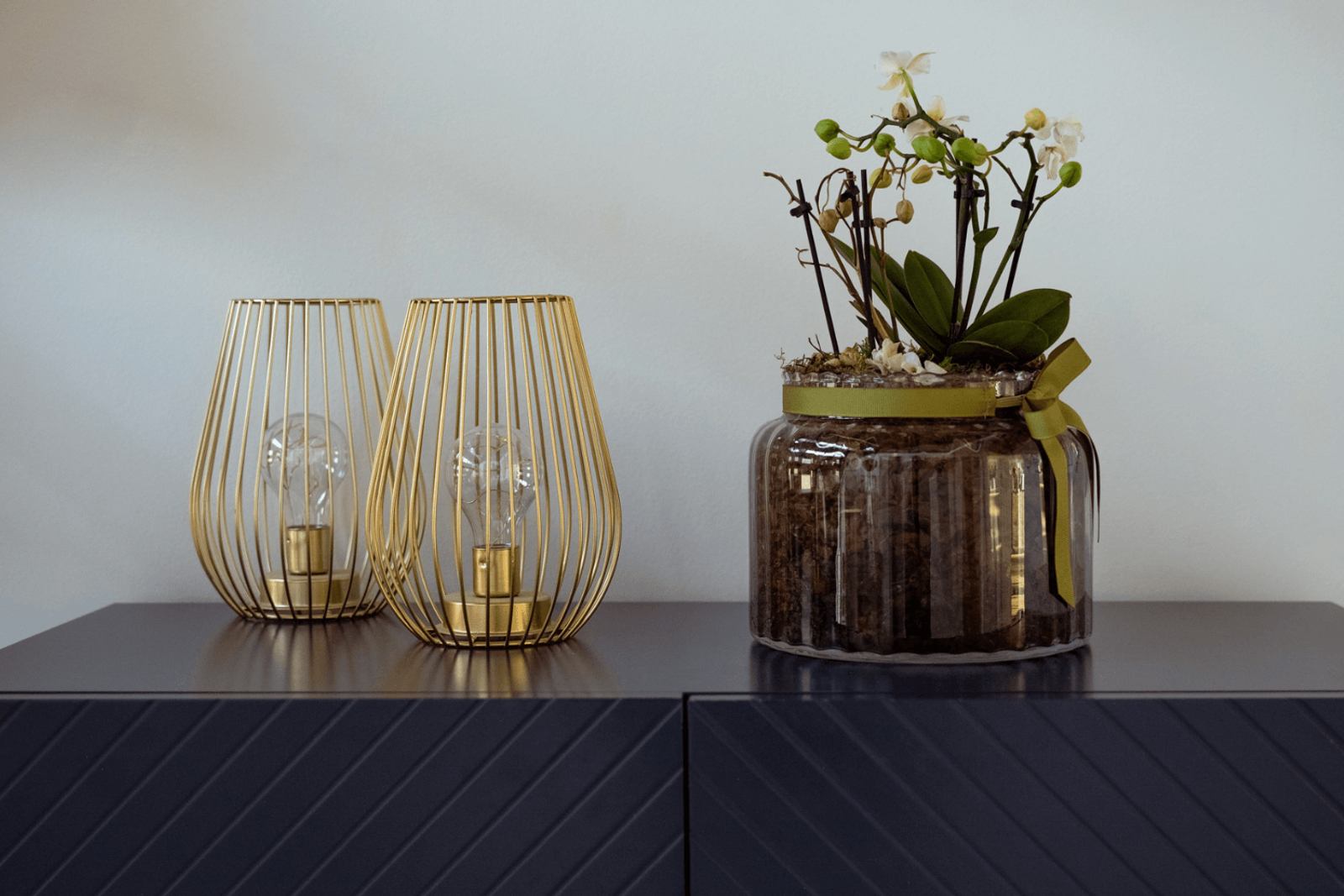 Sevenoaks interior design detail showing cabinet styling with gold table lamps and orchid plant