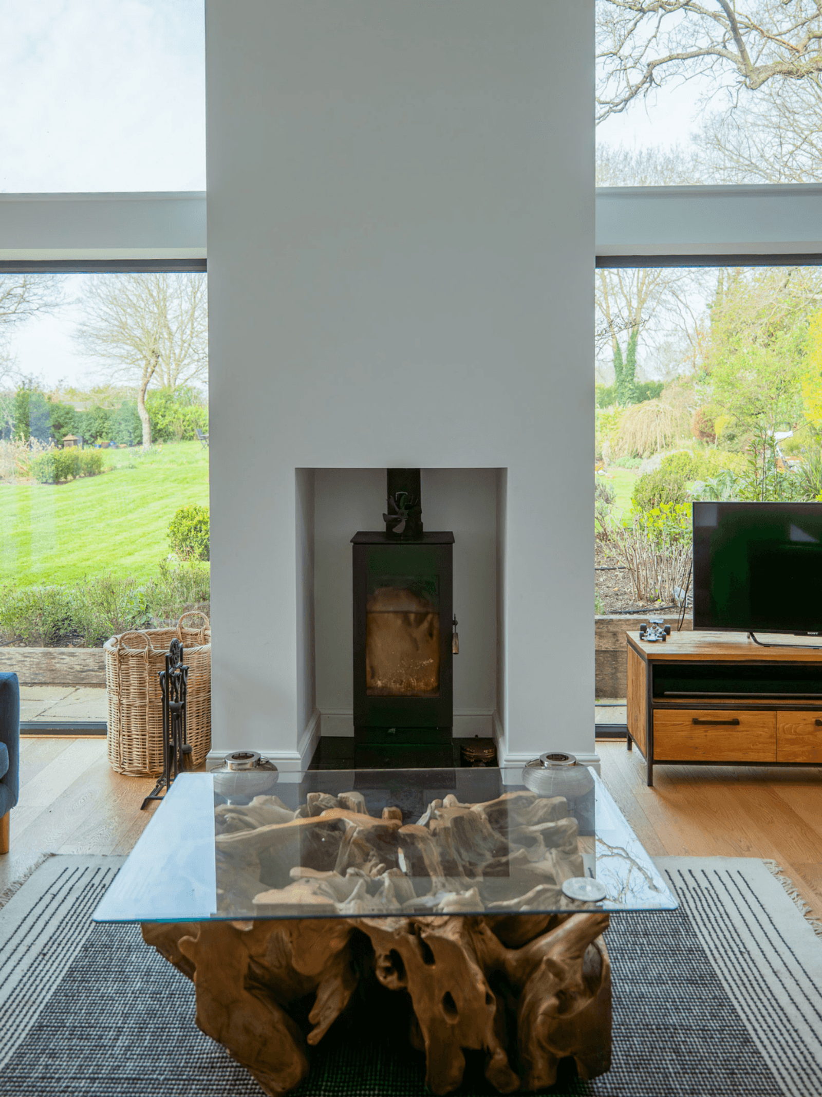 Kent home interiors with a modern wood-burning stove and double-height glazing in a contemporary living room