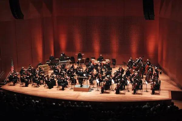 Orchestra musicians performing on stage at Lincoln Center