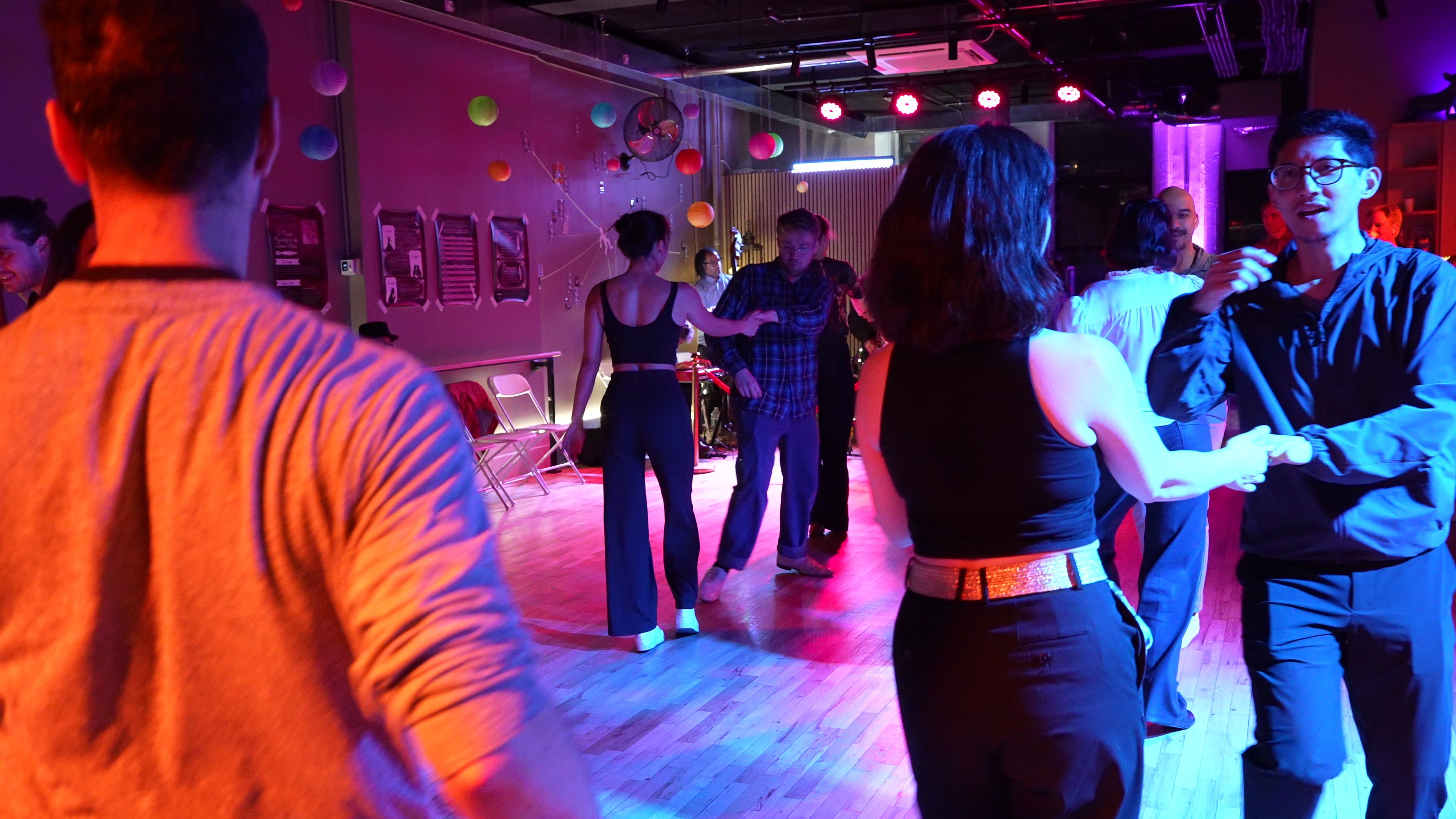 Couples fill the floor at a Big Apple Ballroom event night, the live band playing behind the red rope.