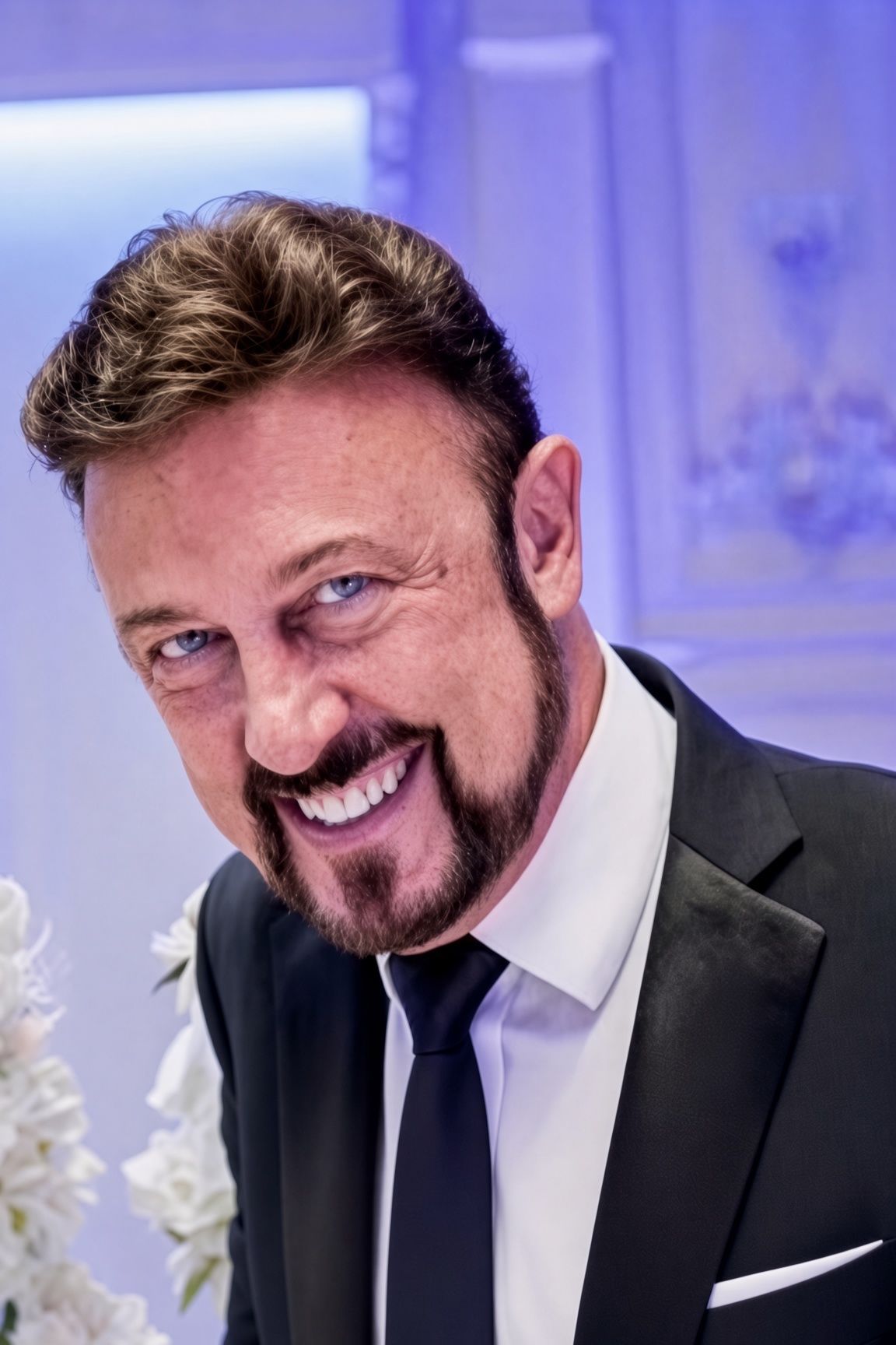 Edward Simon, smiling in a black suit and tie