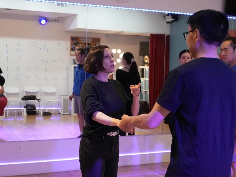 Sophie teaching a West Coast Swing class at Big Apple Ballroom, demonstrating a hand connection with a student.
