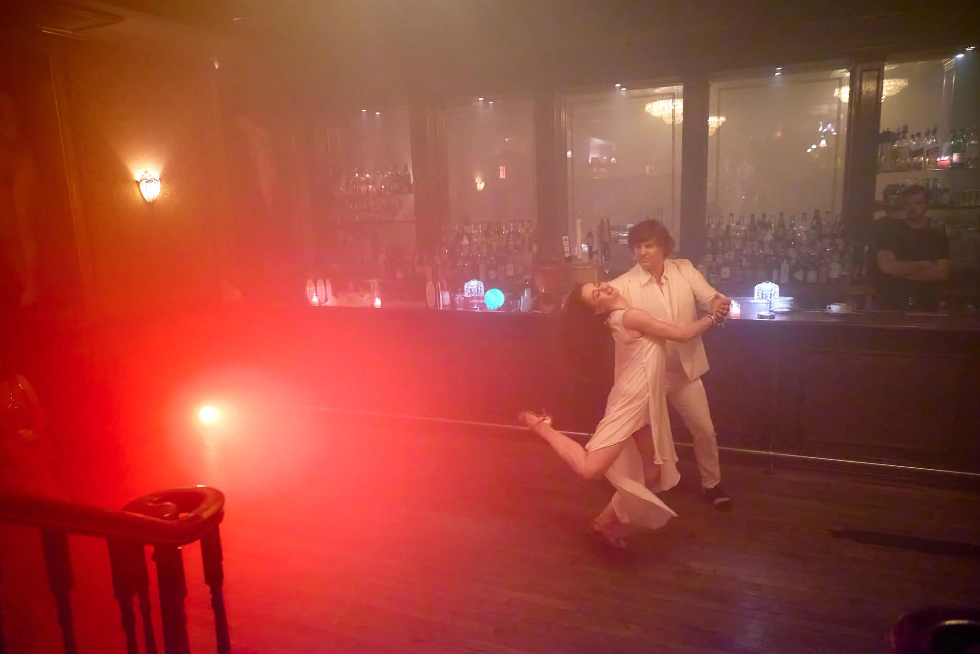Tybaldt dips Vanda in a deep zouk cambré, both in white, red light cutting through the haze at the NY Nightlife Showcase.