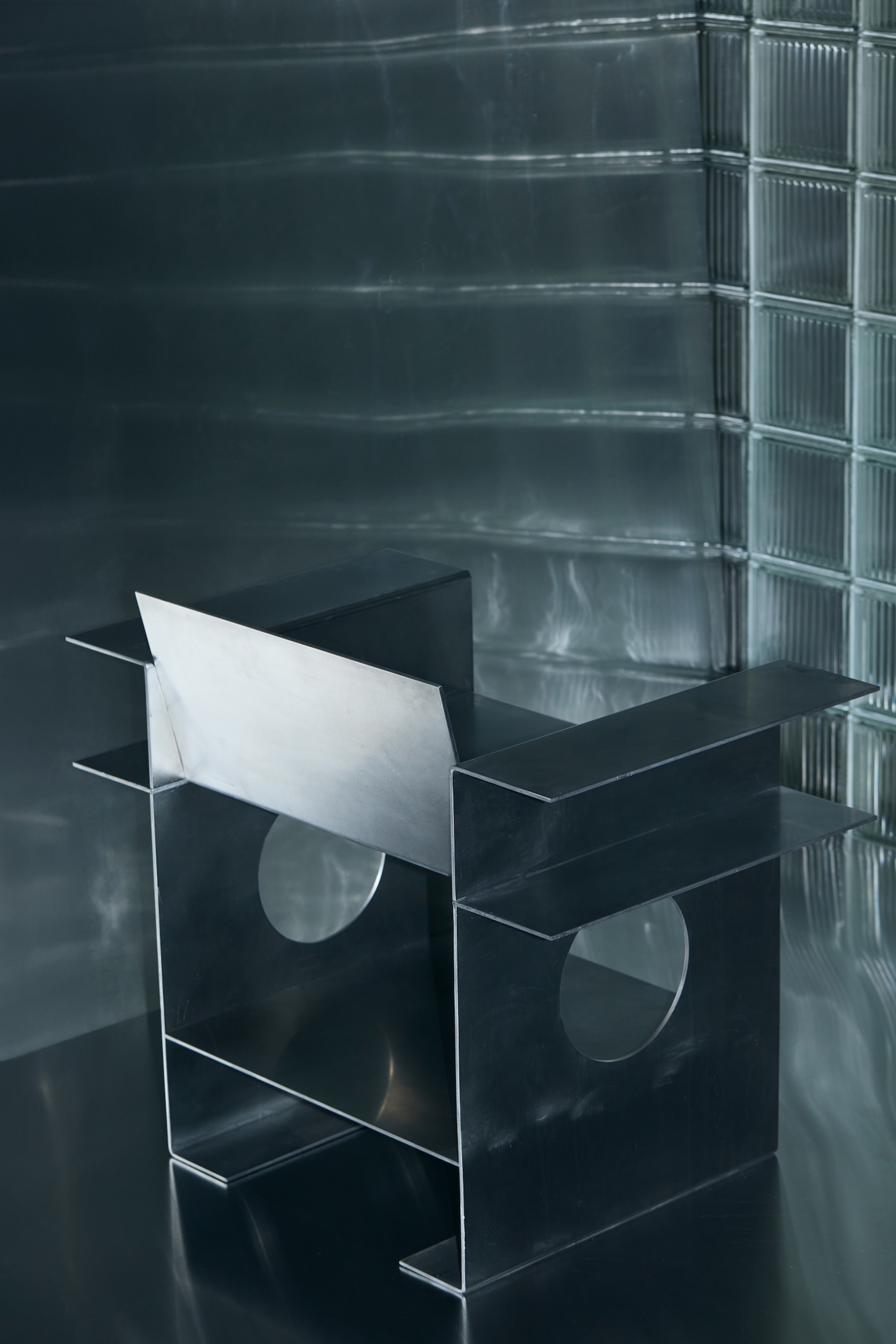 Placeholder reference image: Angular metal chair with an open frame and circular cut-outs.