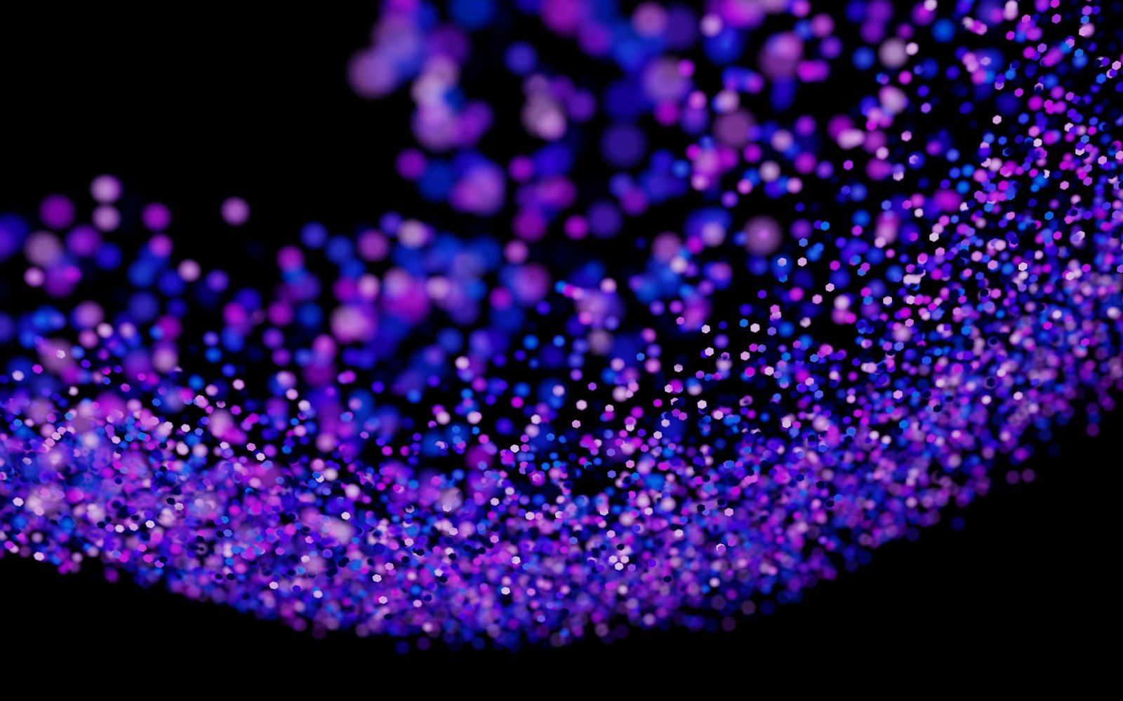 A field of glowing purple and blue particles on black