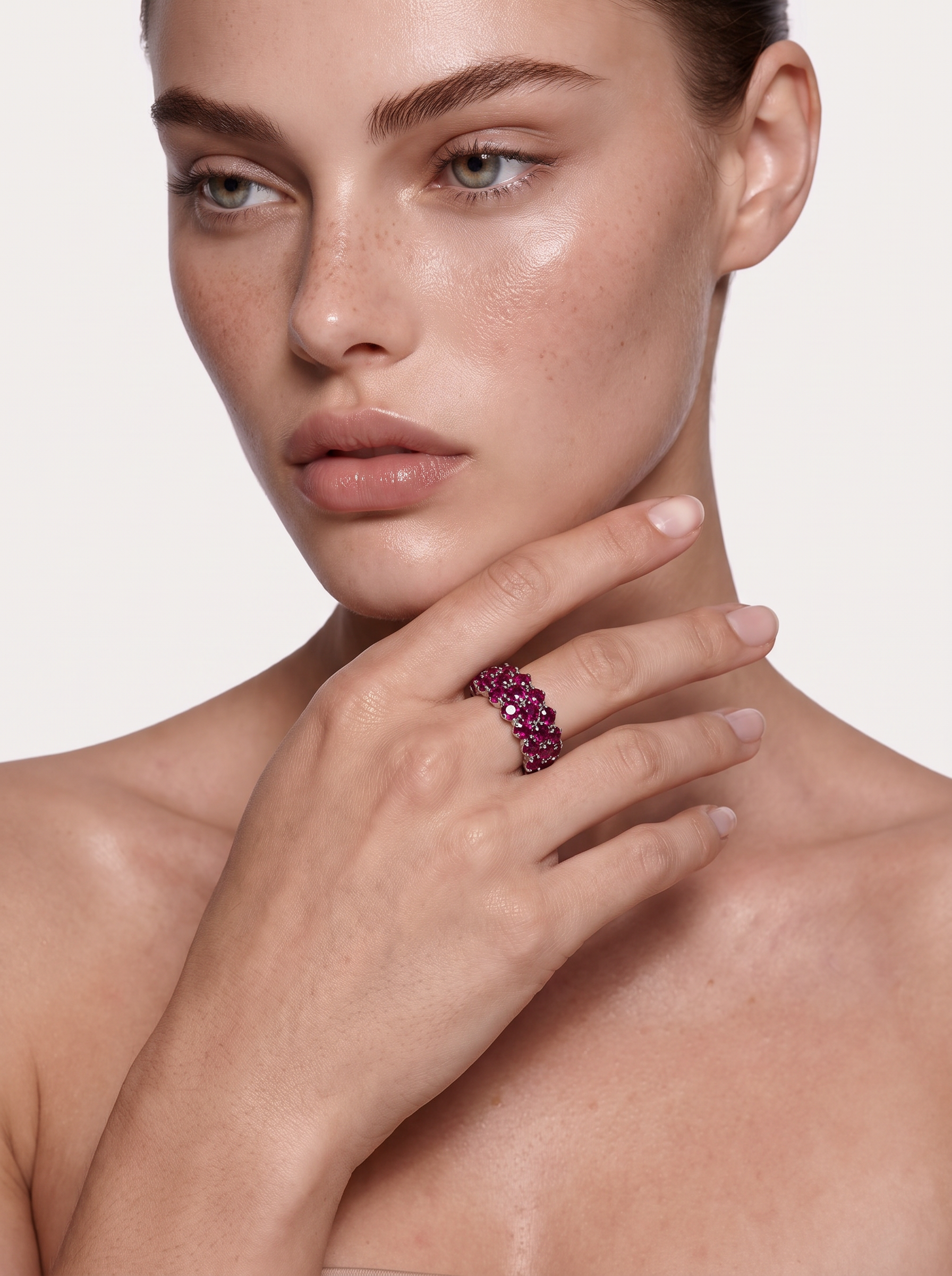 Close-up of the wine-red garnet band ring on the hand, near the face
