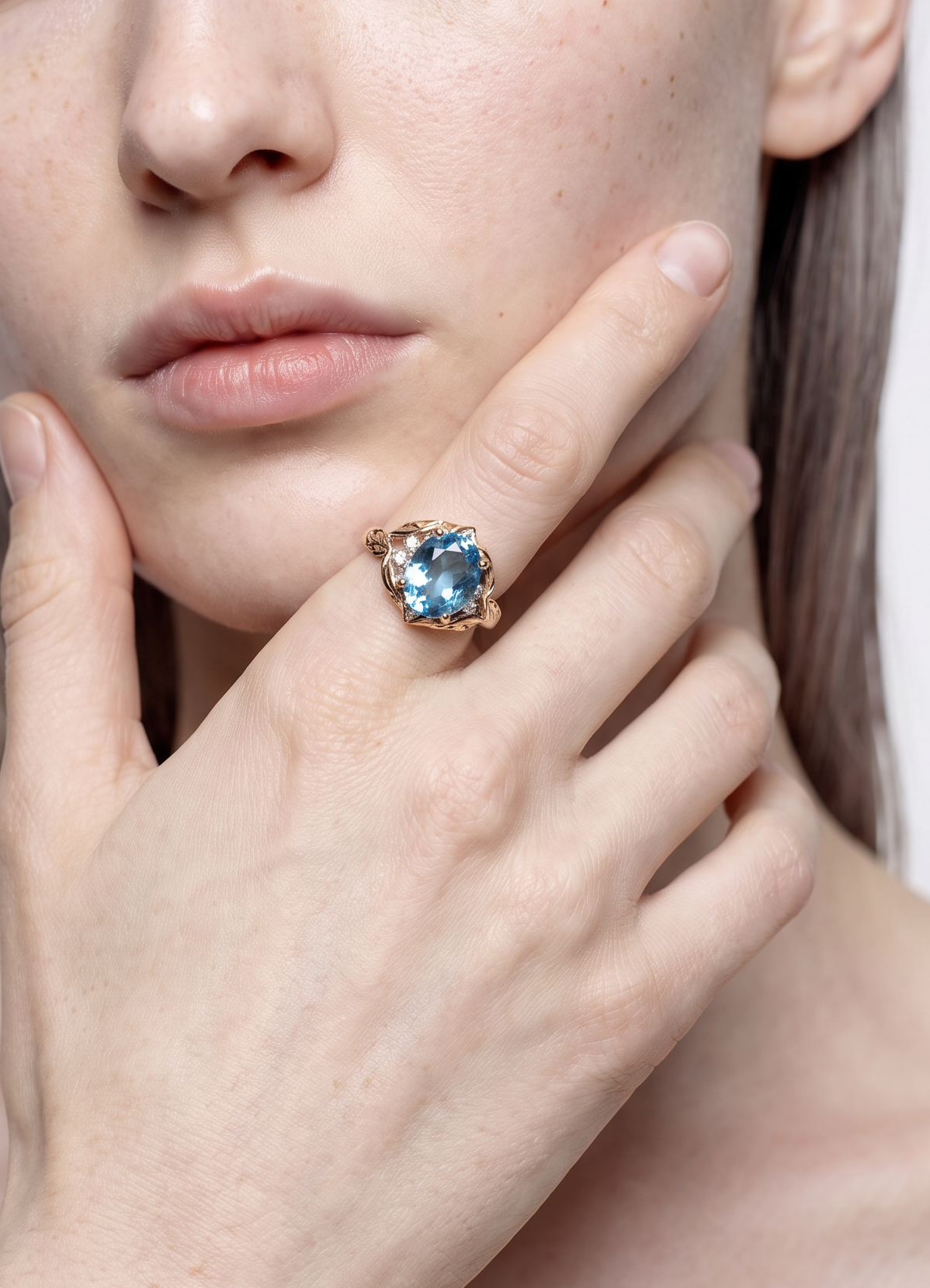 Model wearing the Sea Leaf blue topaz leaf ring, hand at the chin