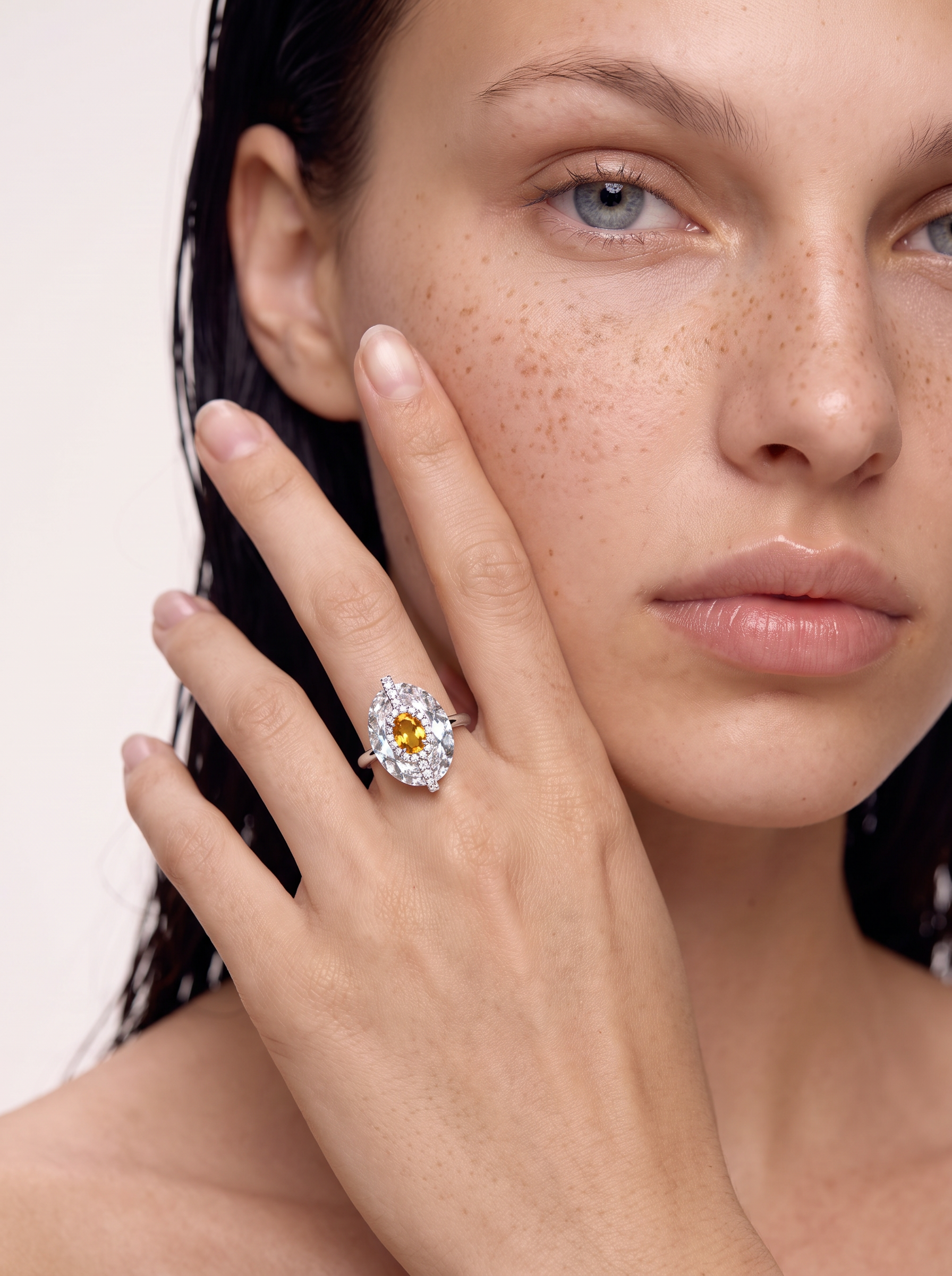 Model wearing the Ember in Ice clear quartz and citrine ring, hand at the face