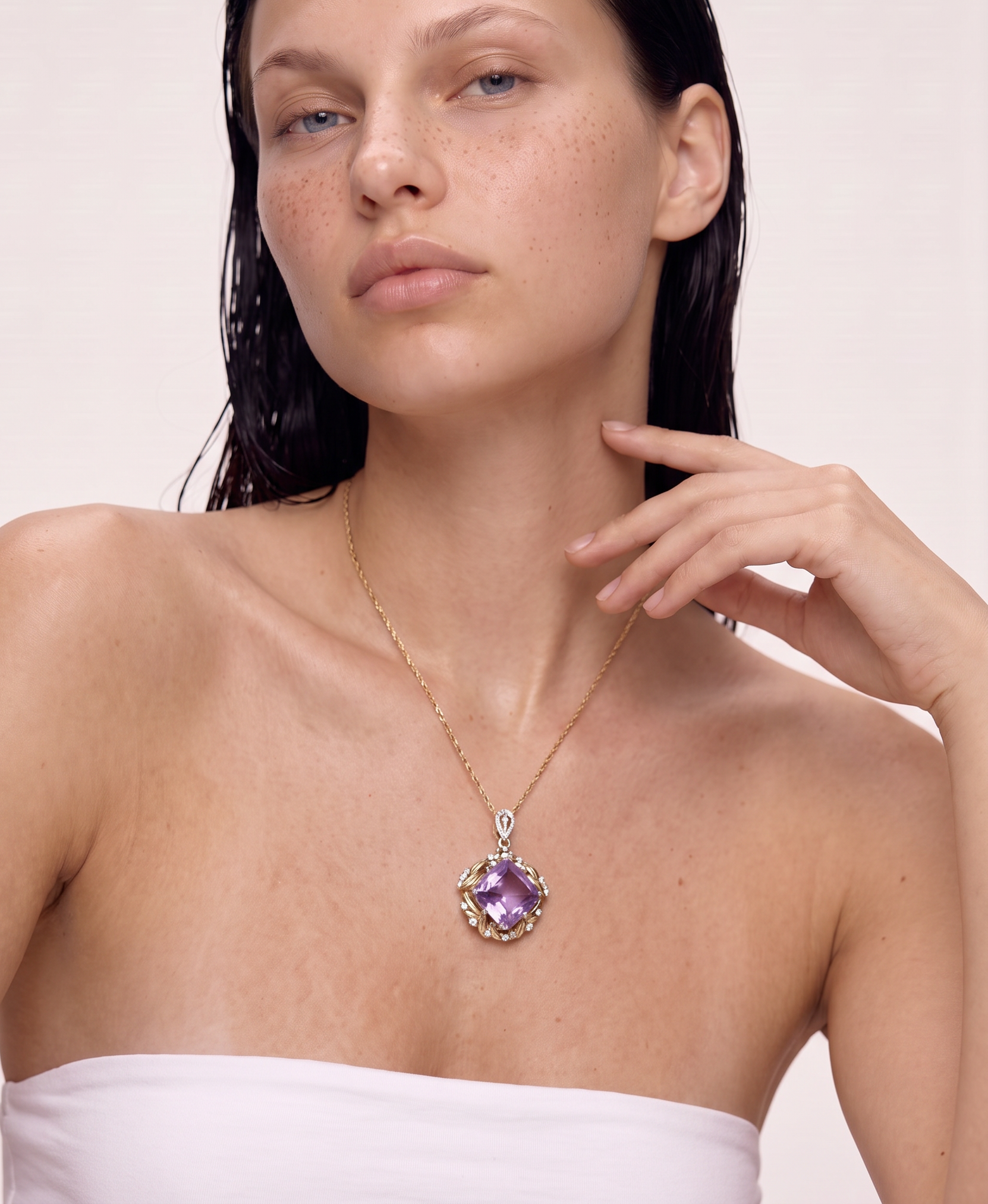 Model wearing the Violet Summit sugarloaf amethyst pendant necklace, hand raised to the chin