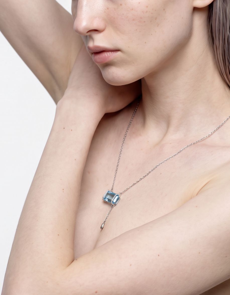 Aquamarine bar pendant in sterling silver worn at the neckline, arm raised behind the head