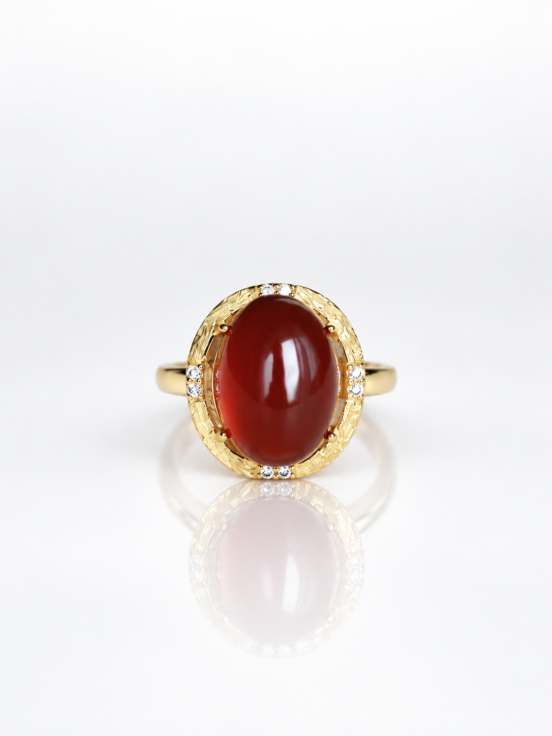 Red garnet oval cabochon ring with a cubic zirconia halo in gold