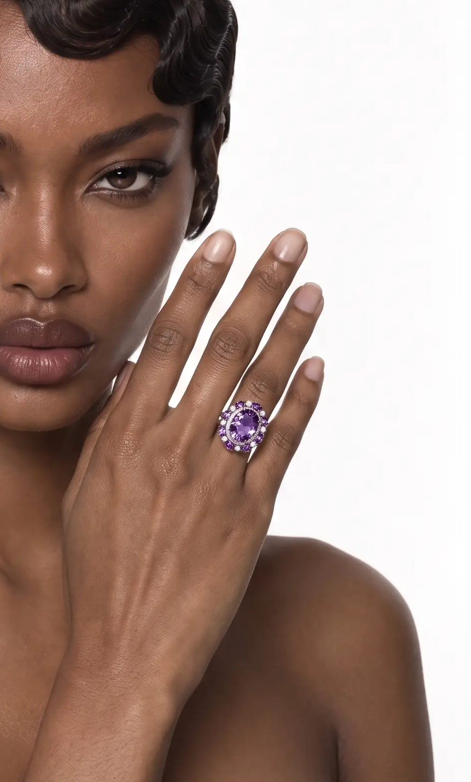 Amethyst cluster ring worn on the finger, hand raised to the face