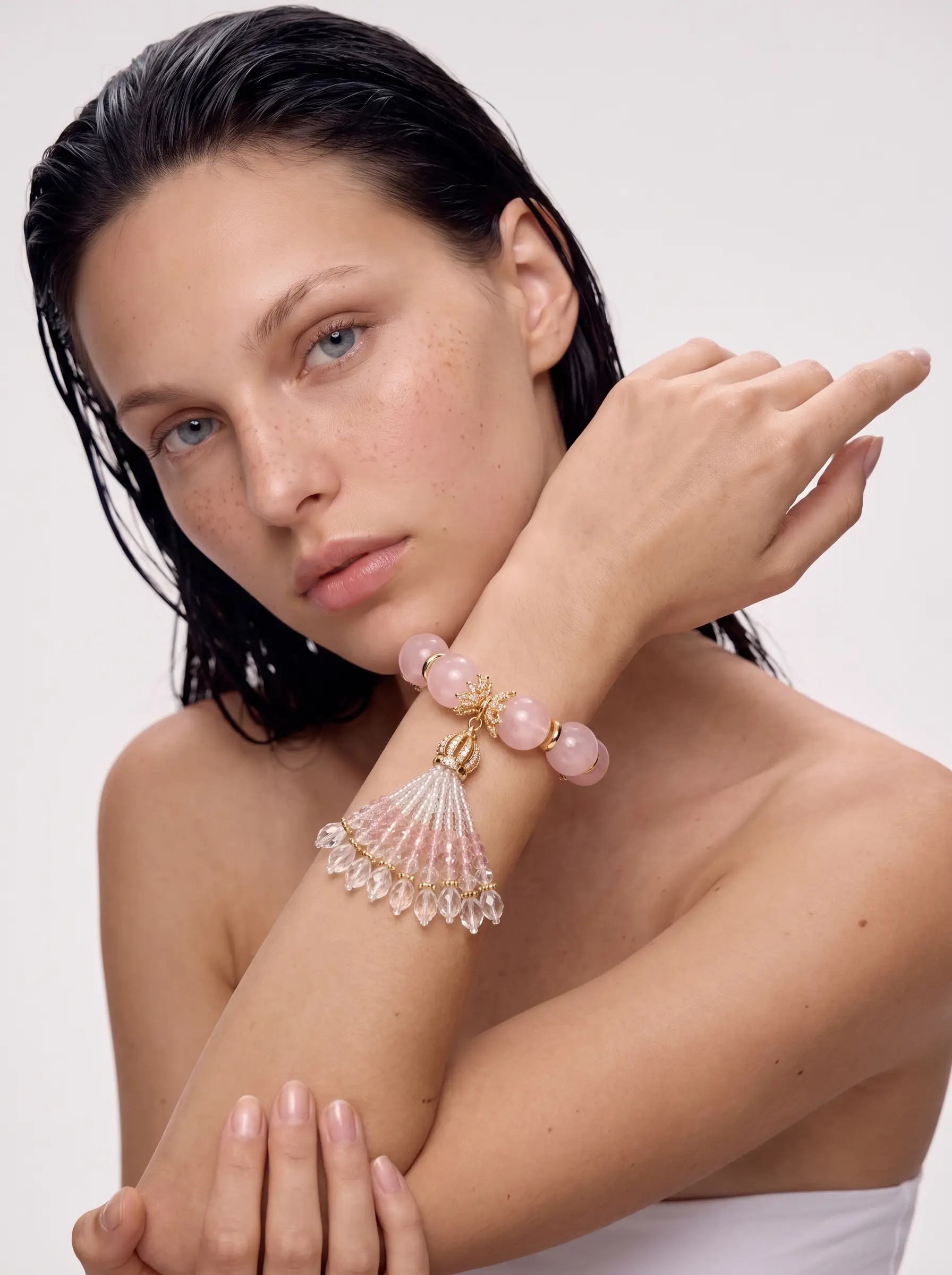 Model wearing the Siren's Fan rose quartz bracelet with glass fan tassel on the wrist