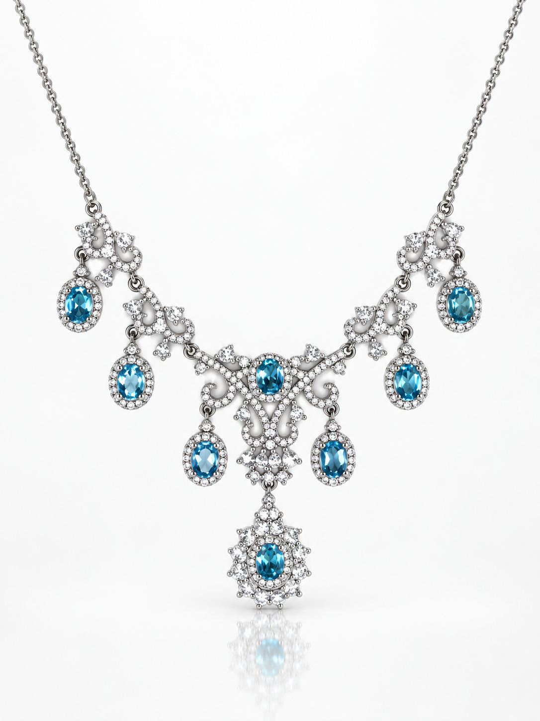 Blue topaz statement necklace with multiple oval blue stones in cubic zirconia lace and cascading drops in sterling silver on a white background