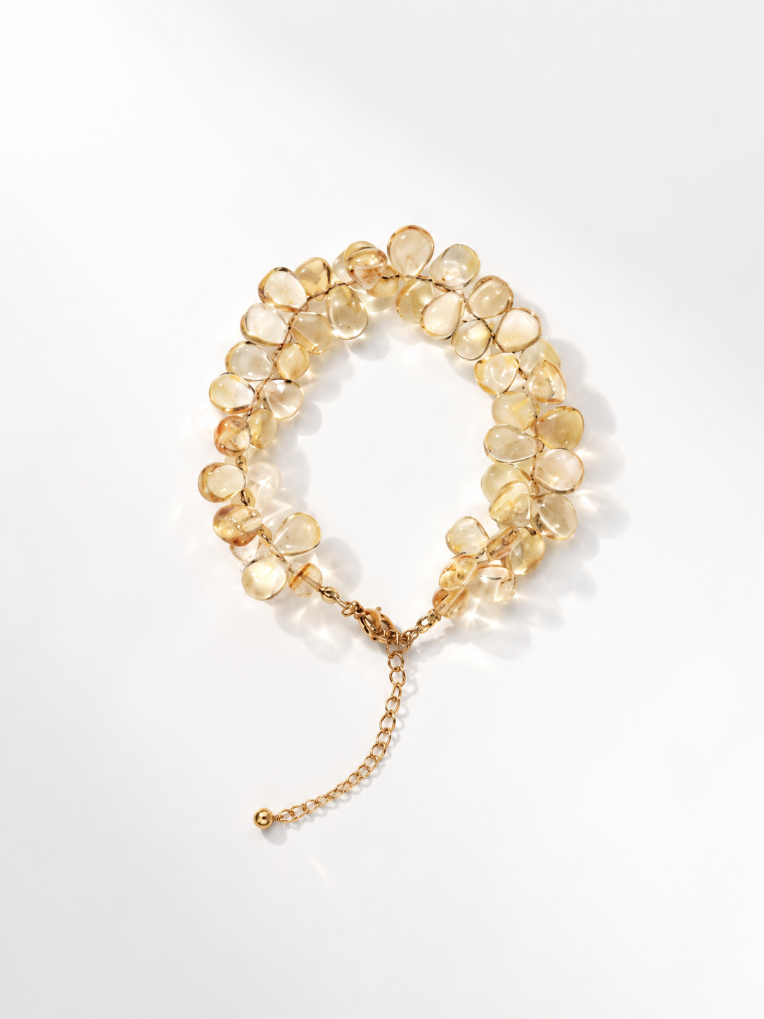 Citrine briolette bracelet shaped like a sheaf of wheat, with an extension chain, on a white background