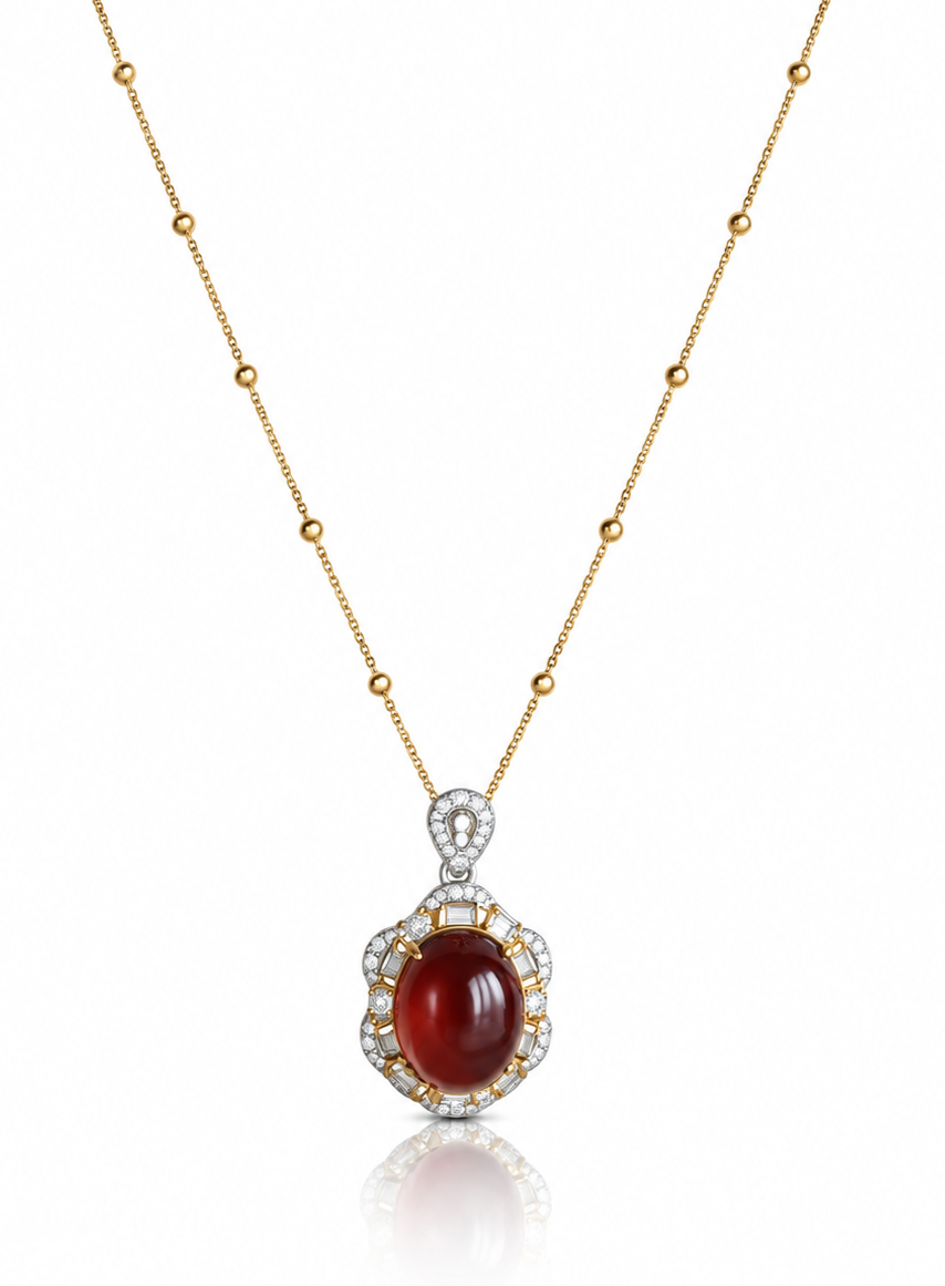 Red garnet oval cabochon pendant necklace with cubic zirconia frame on a beaded gold chain, white background
