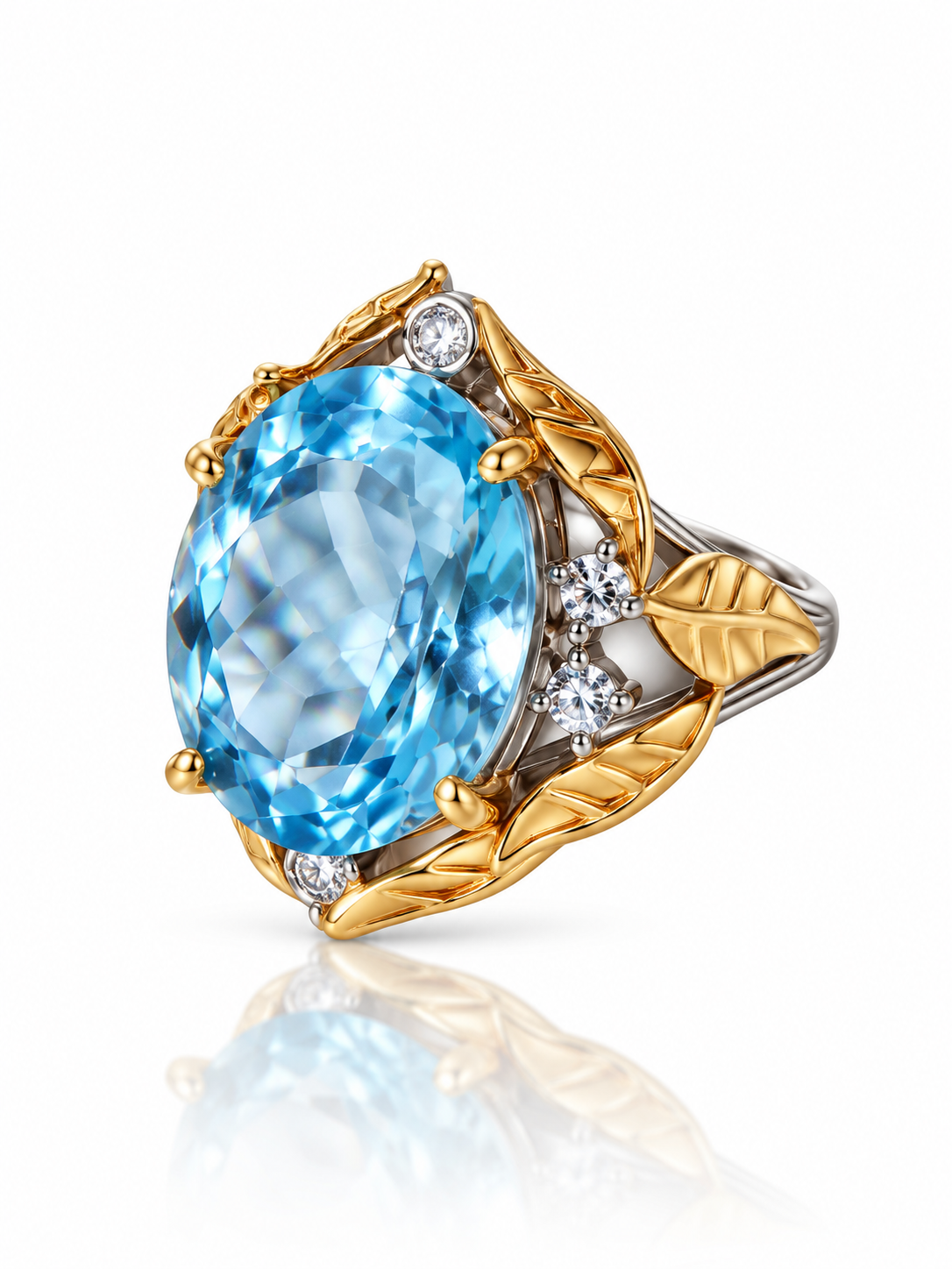 Blue topaz oval ring wrapped in sculpted gold leaves on a two-tone sterling silver band with cubic zirconia accents