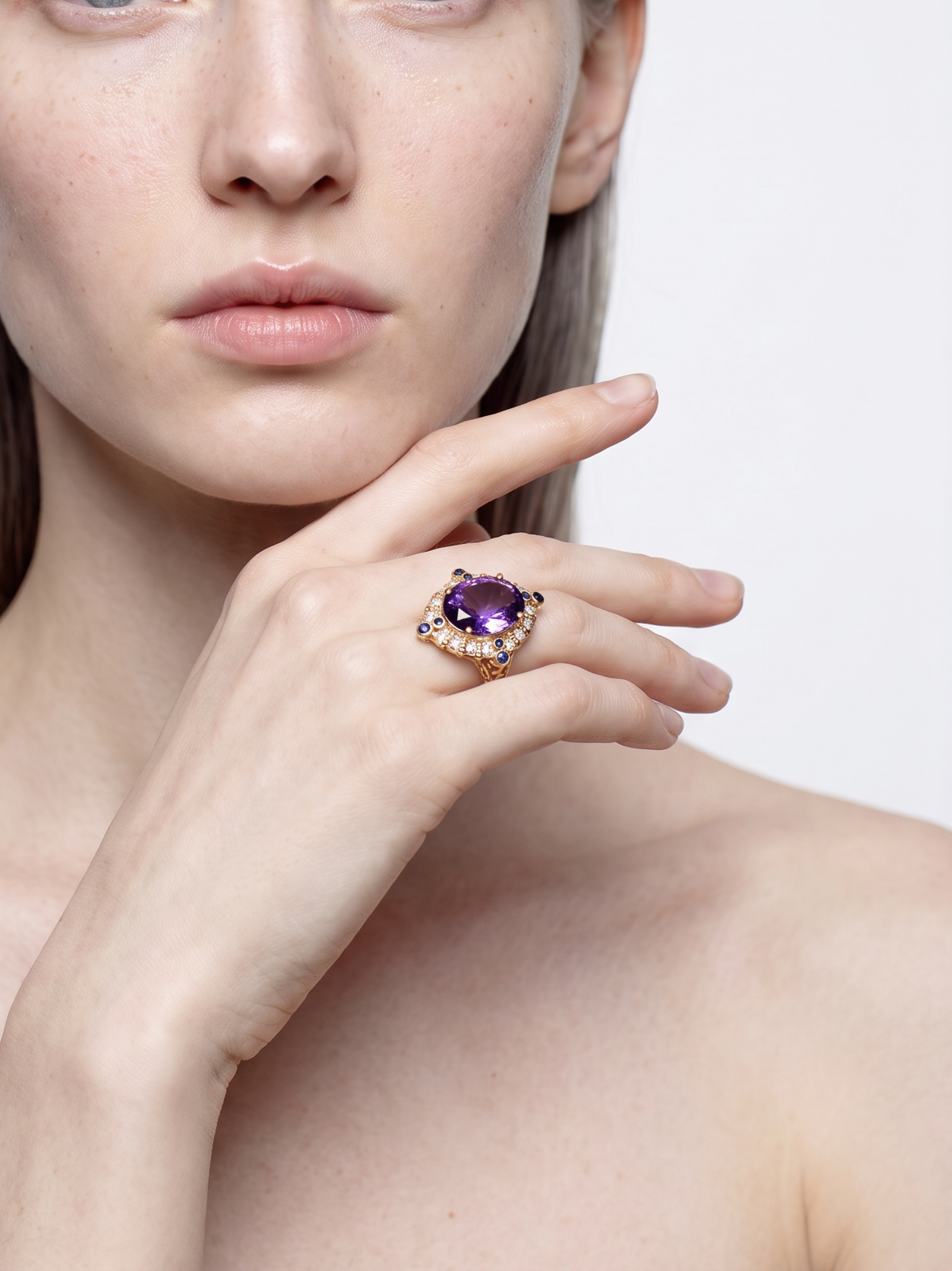 Amethyst cocktail ring with gold and lapis detail worn on the finger, front view
