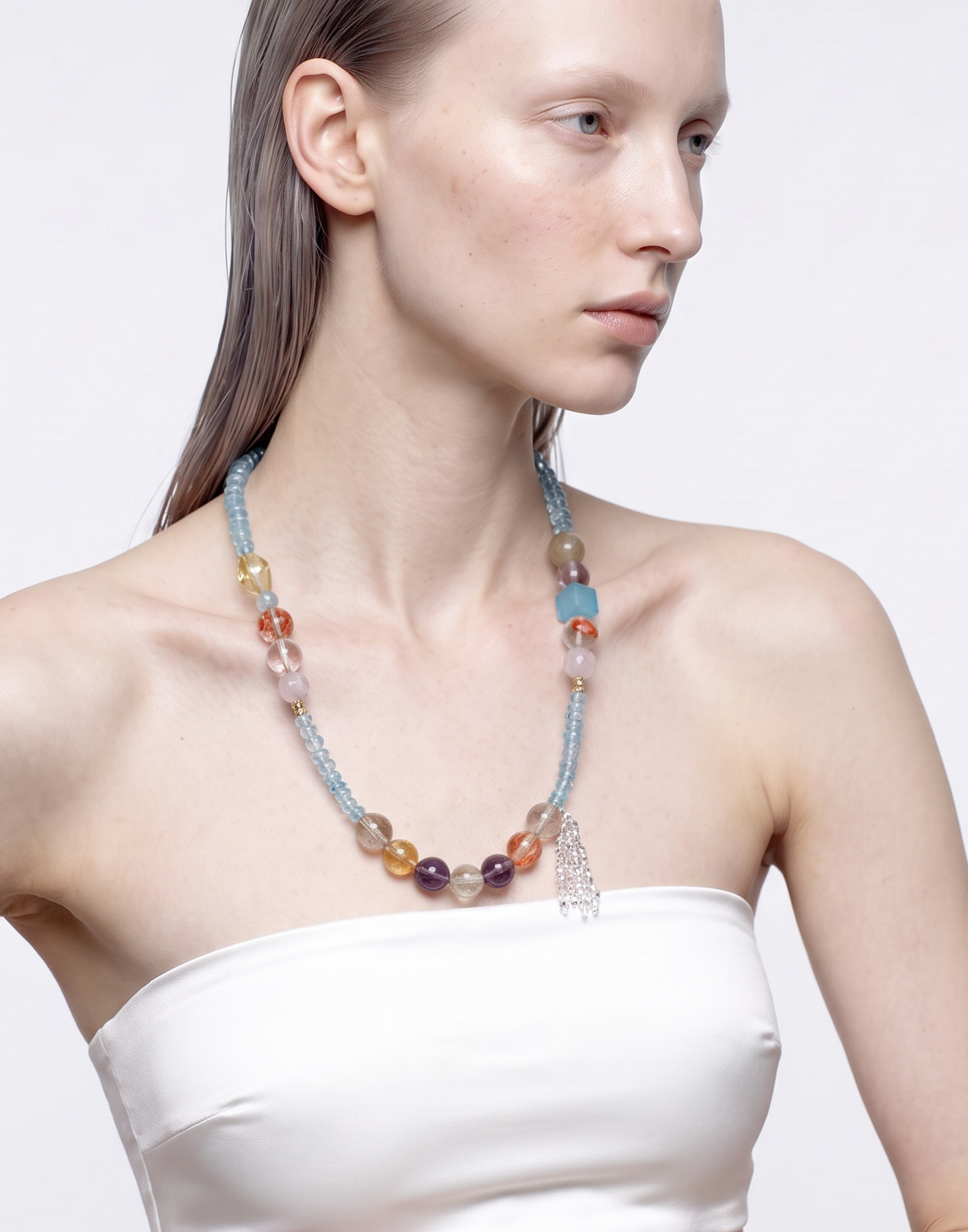 Model wearing the Coral Cascade blue topaz and mixed crystal long necklace, front view