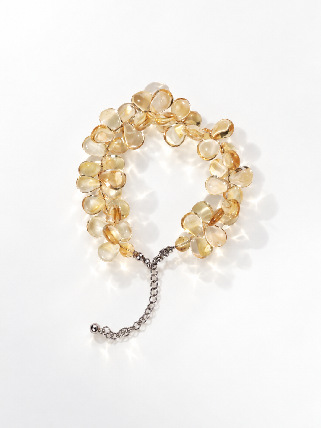 Citrine briolette cluster bracelet with golden teardrop stones and an extension chain on a white background
