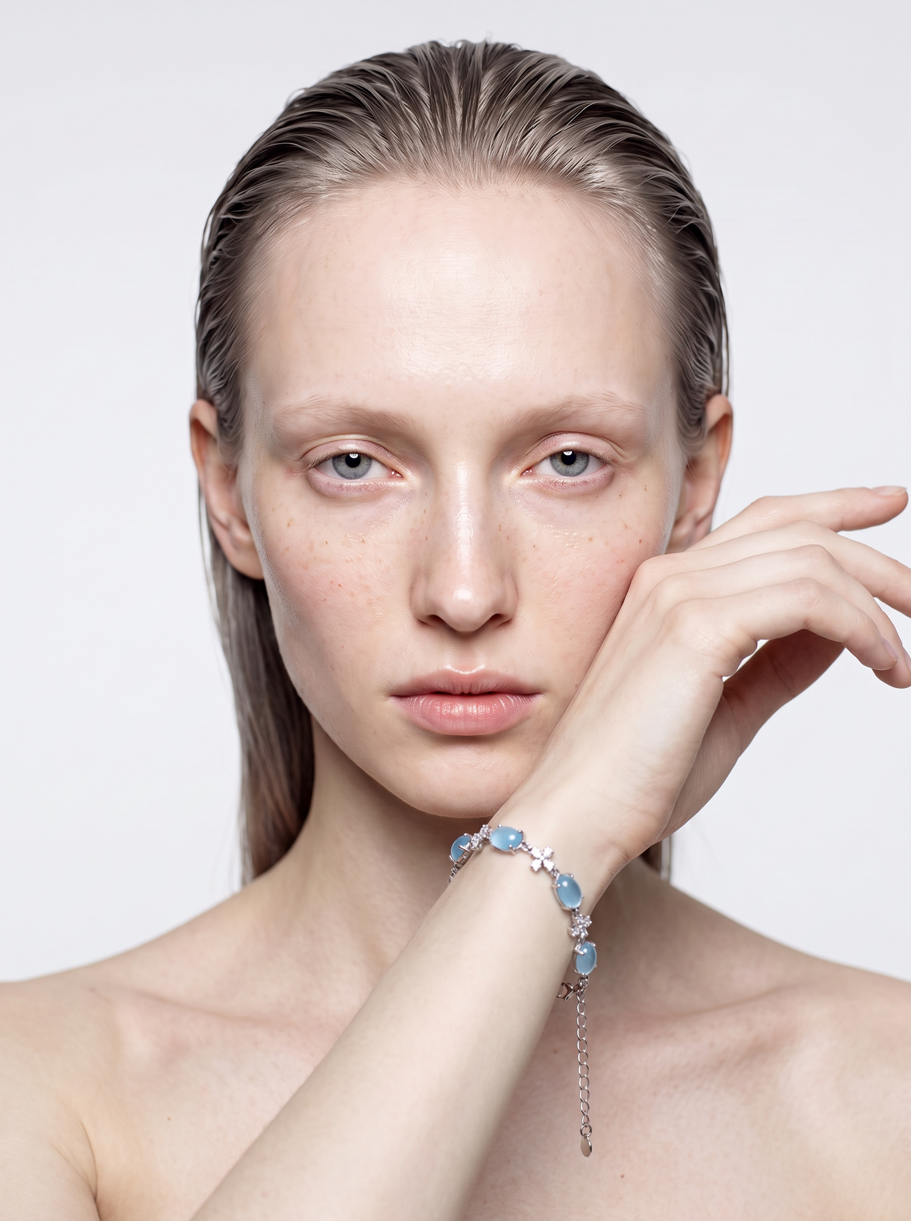 Model wearing the Shallow Water aquamarine cabochon bracelet on the wrist, hand resting on the shoulder