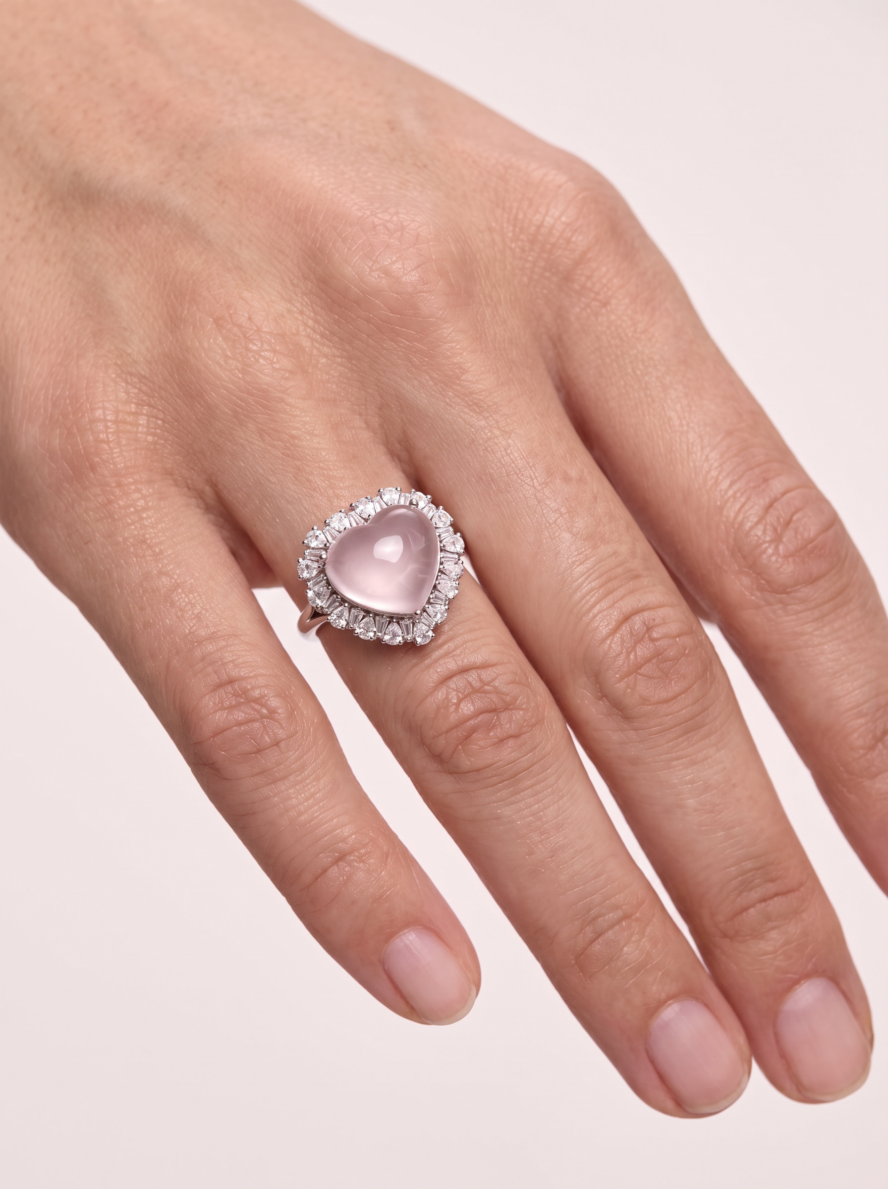 Close-up of the Blush Heart rose quartz ring worn on the finger
