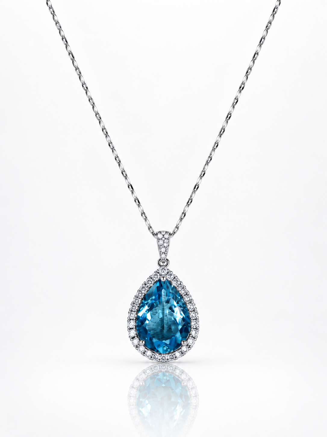 London blue topaz pear-cut pendant necklace with cubic zirconia halo in sterling silver on a white background