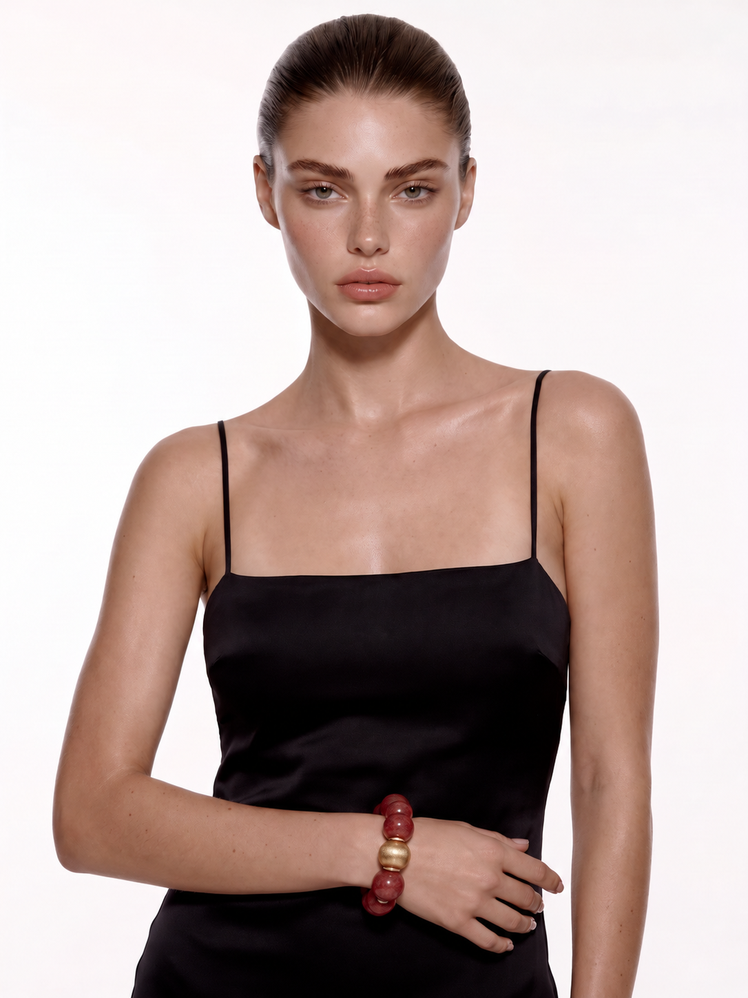 Strawberry quartz bracelet with gold accents worn on the wrist, full-length view