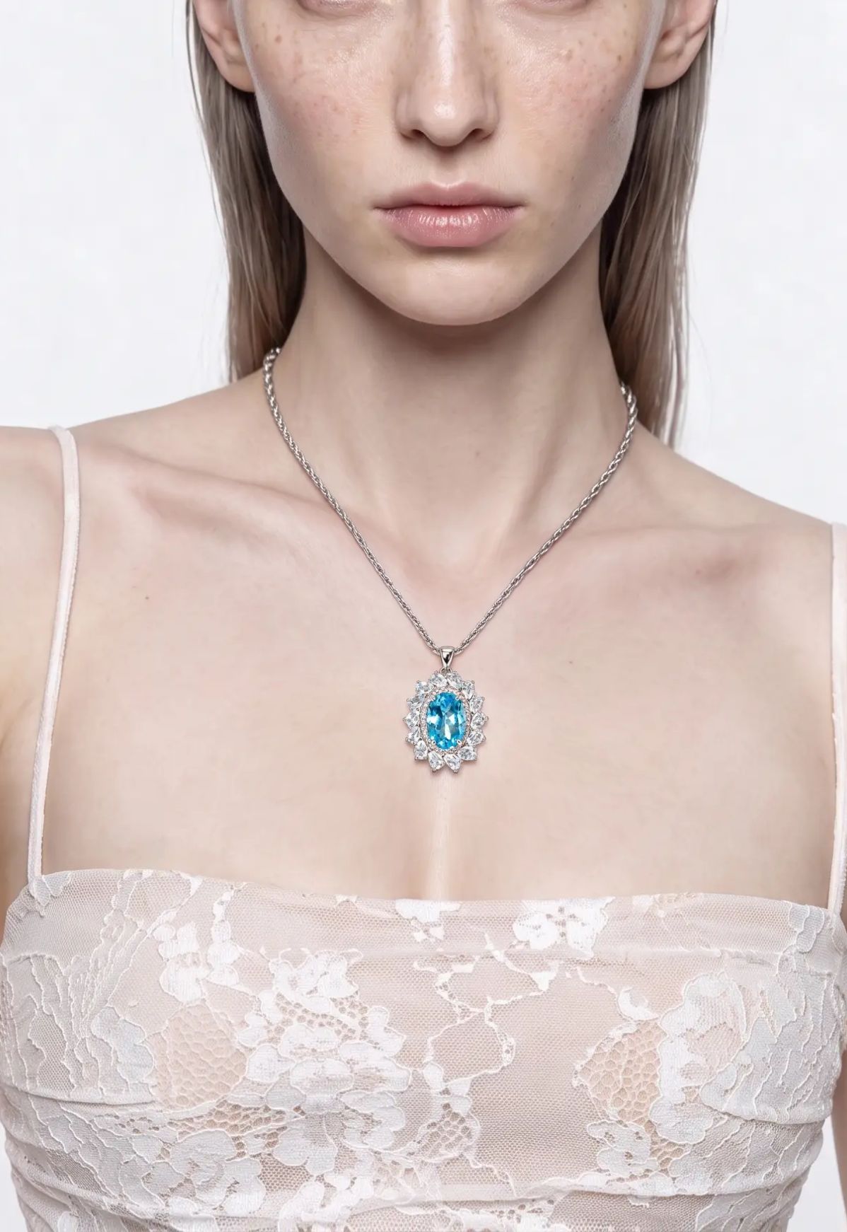 Blue topaz and aquamarine flower pendant in sterling silver worn at the neckline