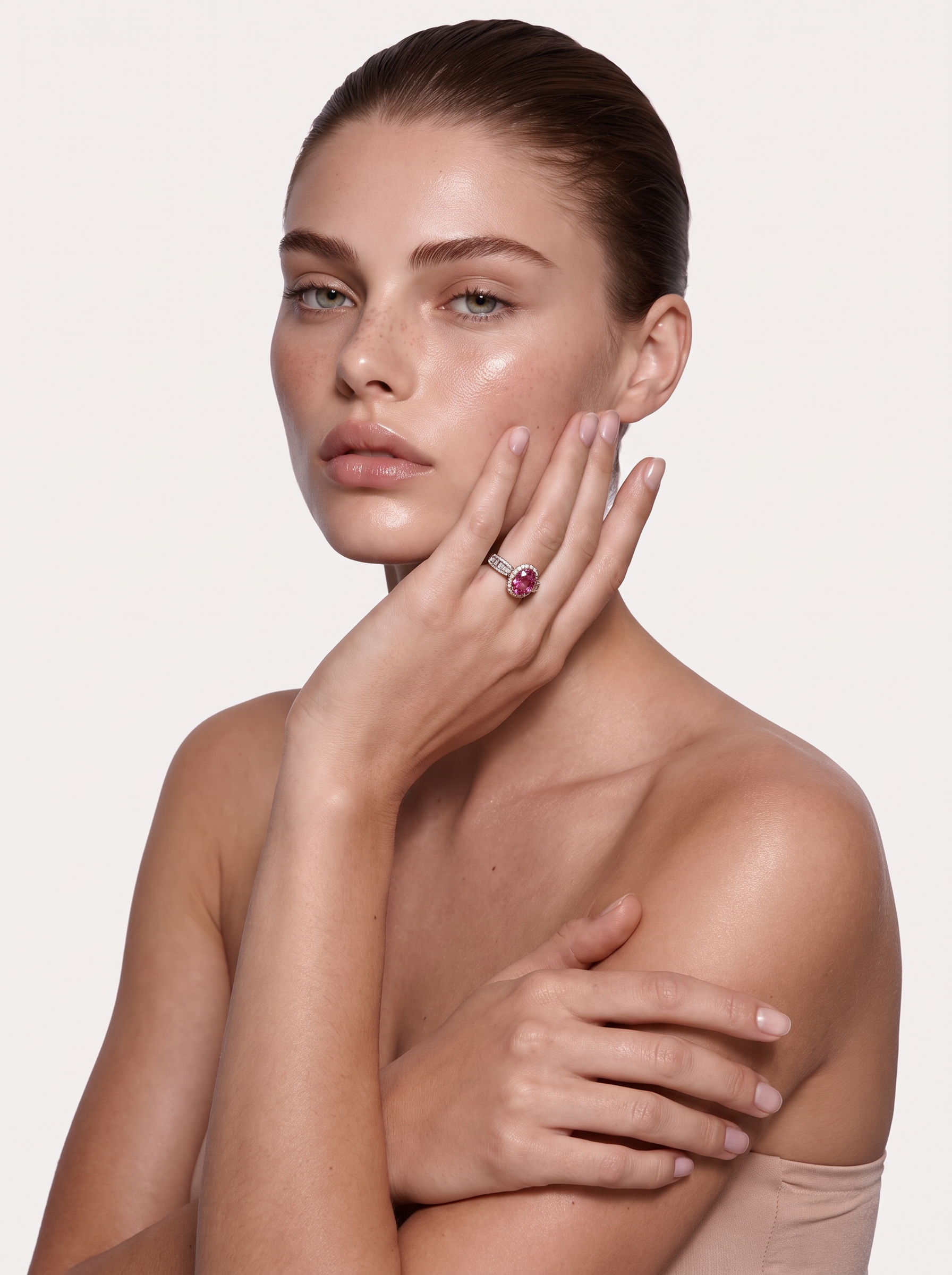 Model wearing the Coral Flame pink topaz halo ring, hand raised to the face