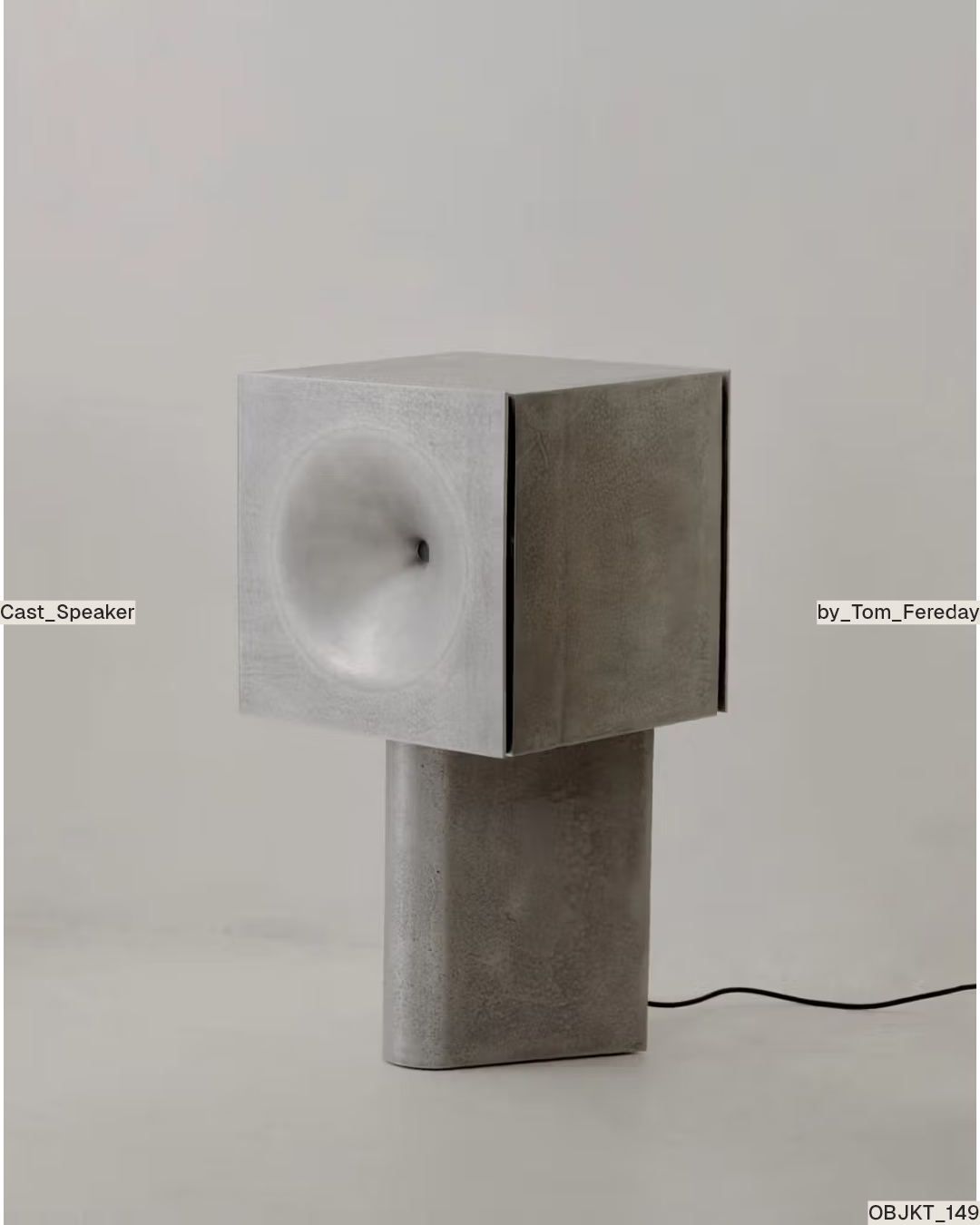 Cast cubic speaker with a deep conical horn on a solid pedestal.