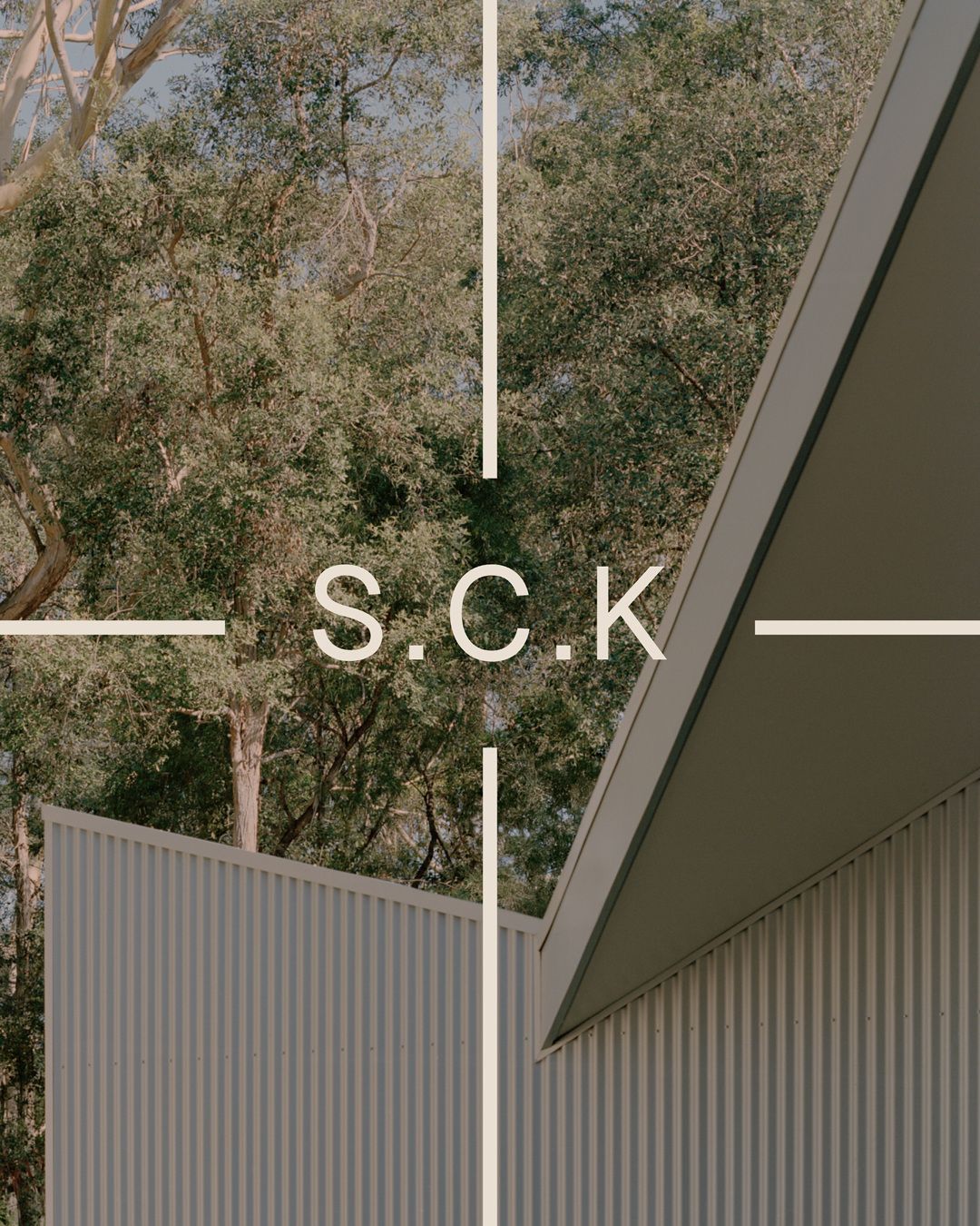 S.C.K and a crosshair over corrugated metal cladding and gum trees.