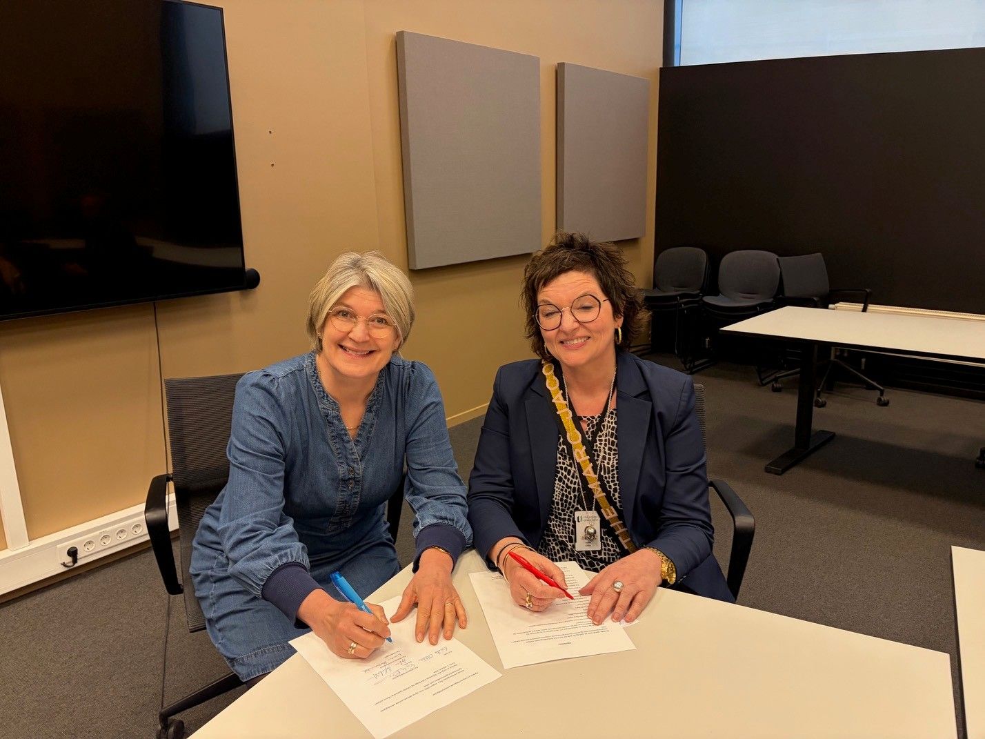 Forhandlingsleder for Lektorlaget Else Leona McClimans og avdelingsdirektør i Utdanningsdirektoratet Grete Ollila signerer arbeidstidsavtalen for de statlige samiske skolene.