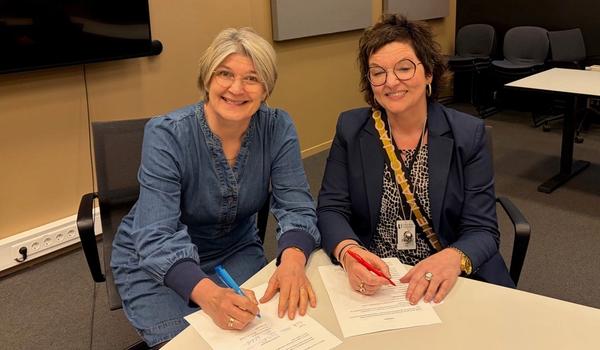 Forhandlingsleder for Lektorlaget Else Leona McClimans og avdelingsdirektør i Utdanningsdirektoratet Grete Ollila signerer arbeidstidsavtalen for de statlige samiske skolene.