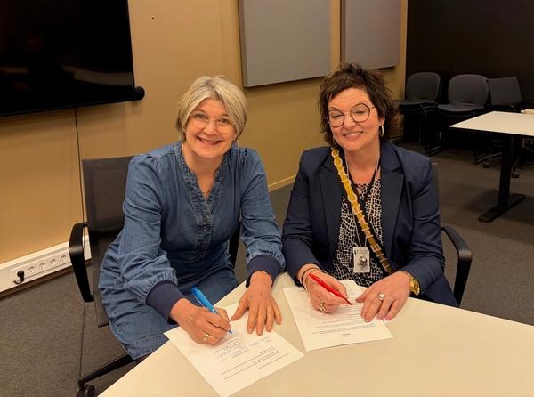 Forhandlingsleder for Lektorlaget Else Leona McClimans og avdelingsdirektør i Utdanningsdirektoratet Grete Ollila signerer arbeidstidsavtalen for de statlige samiske skolene.