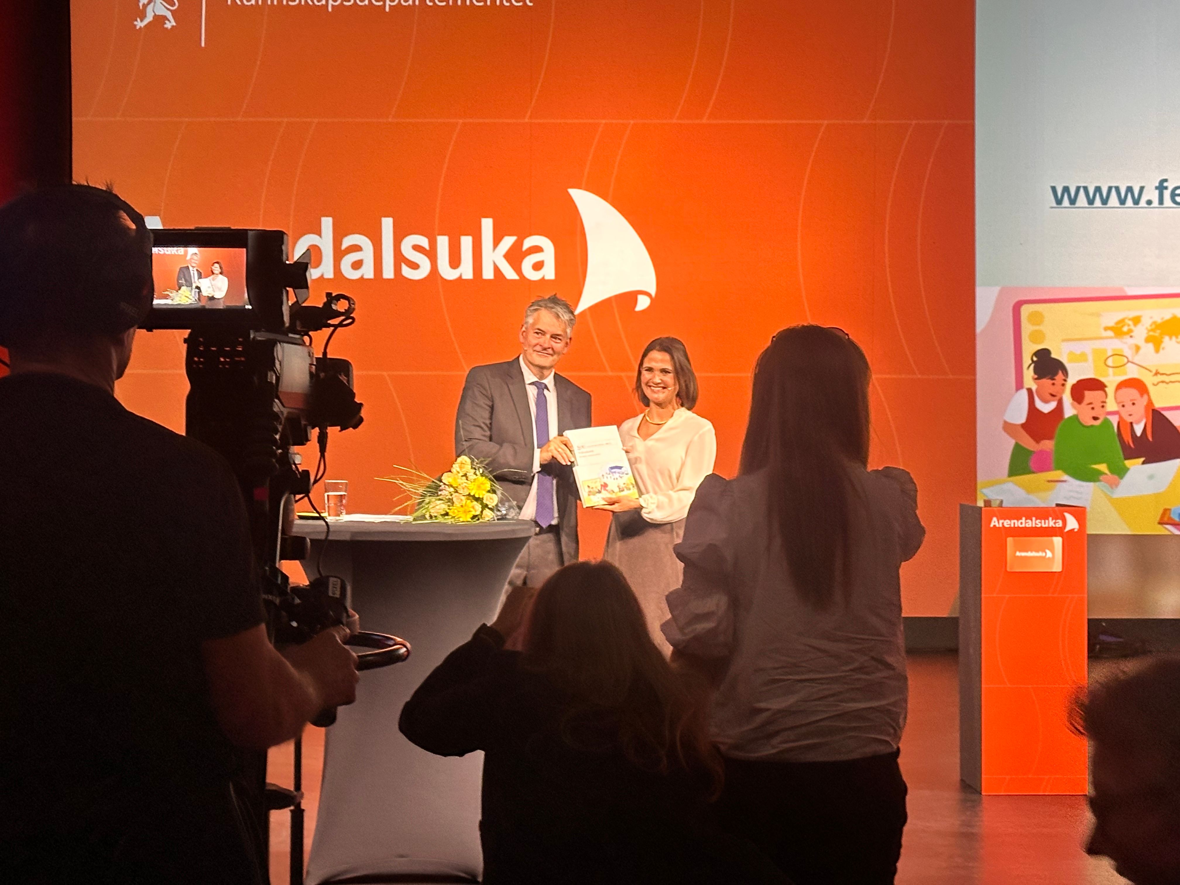 Fellesskoleutvalgets leder Bjørn Haugstad overrekker utvalgets rapport til kunnskapsminister Kari Nesssa Nordtun under Arendalsuka 11. august 2026.