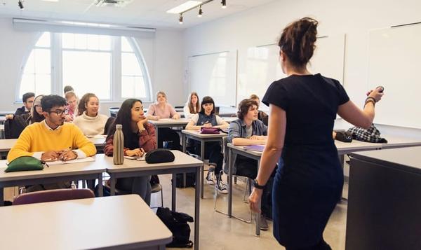 Studenter i et klasserom som følger med på en foreleser