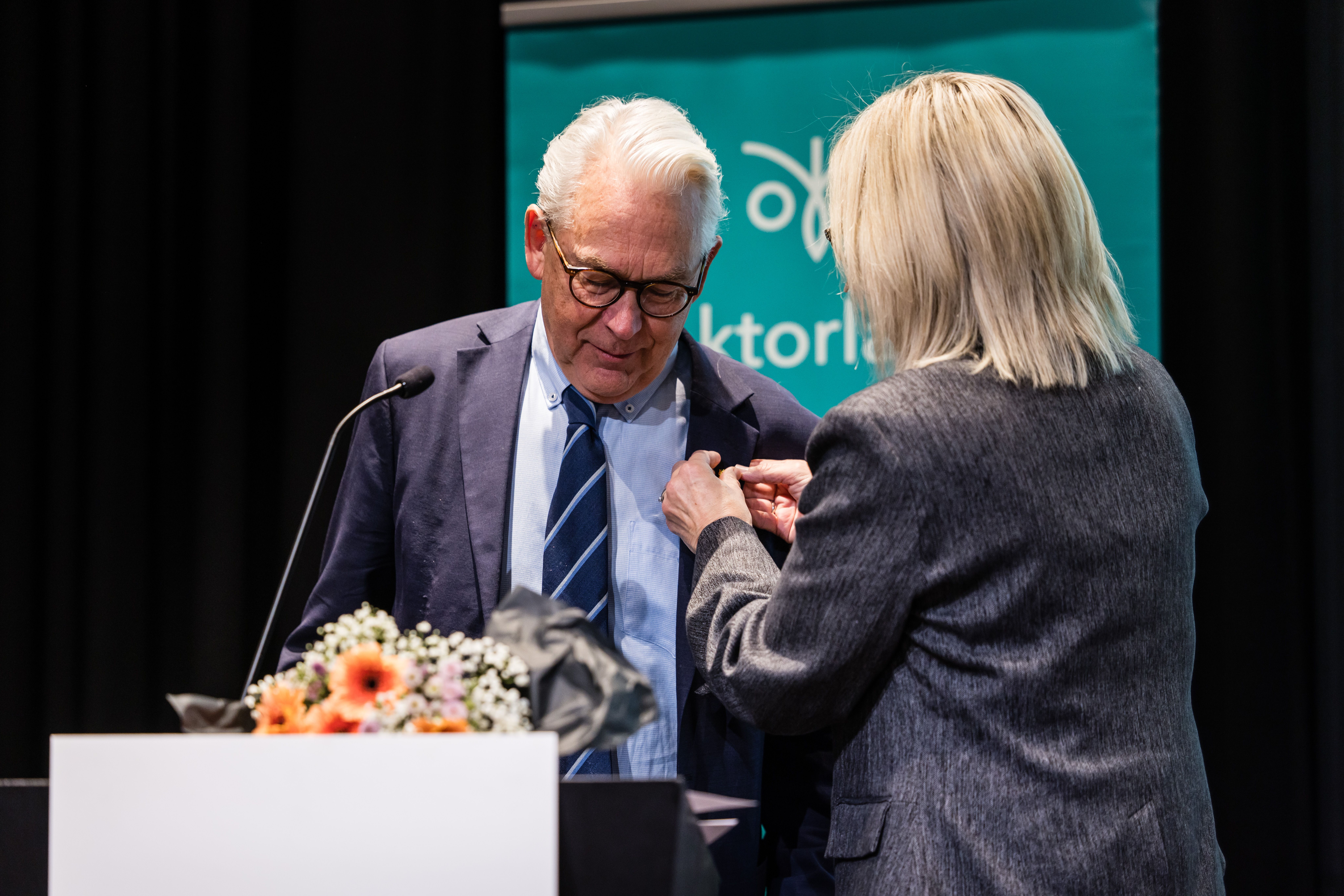 Bilde av Henning Wold som får Lektorlagets ærespris av leder Helle Christin Nyhuus på landsmøtet 2025.