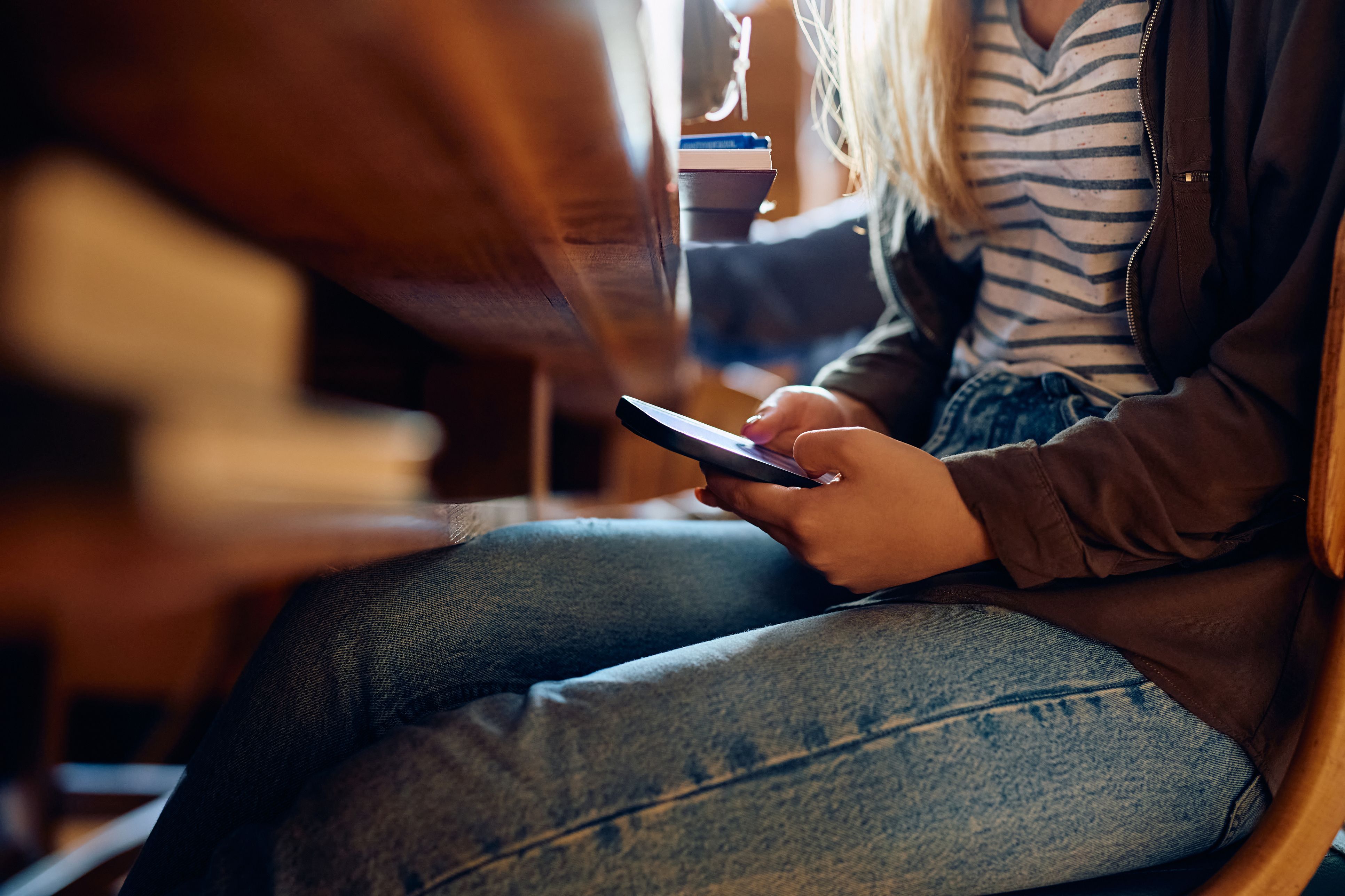 Bilde av en elev som holder på med mobiltelefonen skjult.