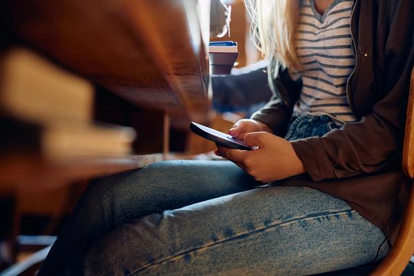 Bilde av en elev som holder på med mobiltelefonen skjult.