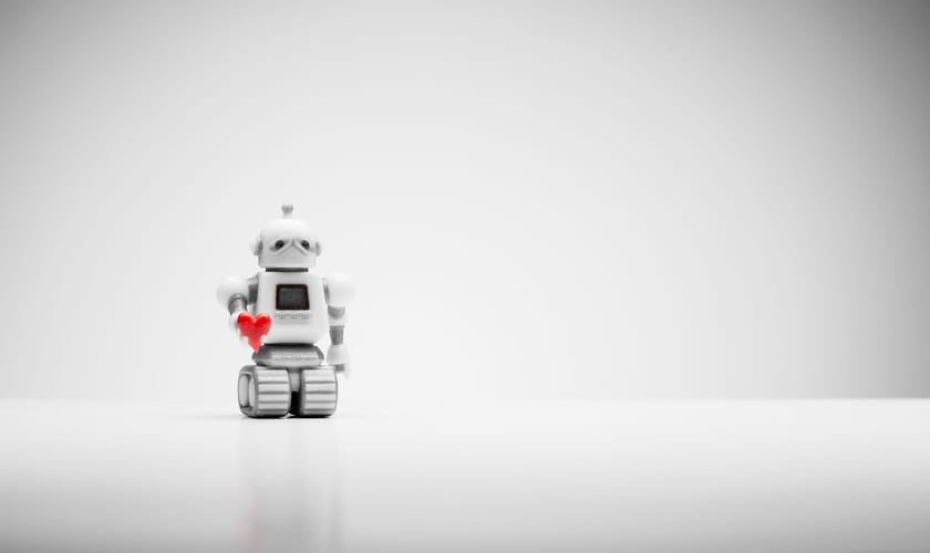 Liten robot holder frem et rødt hjerte