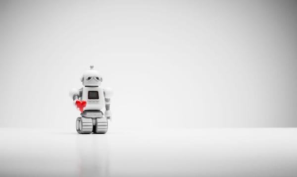 Liten robot holder frem et rødt hjerte